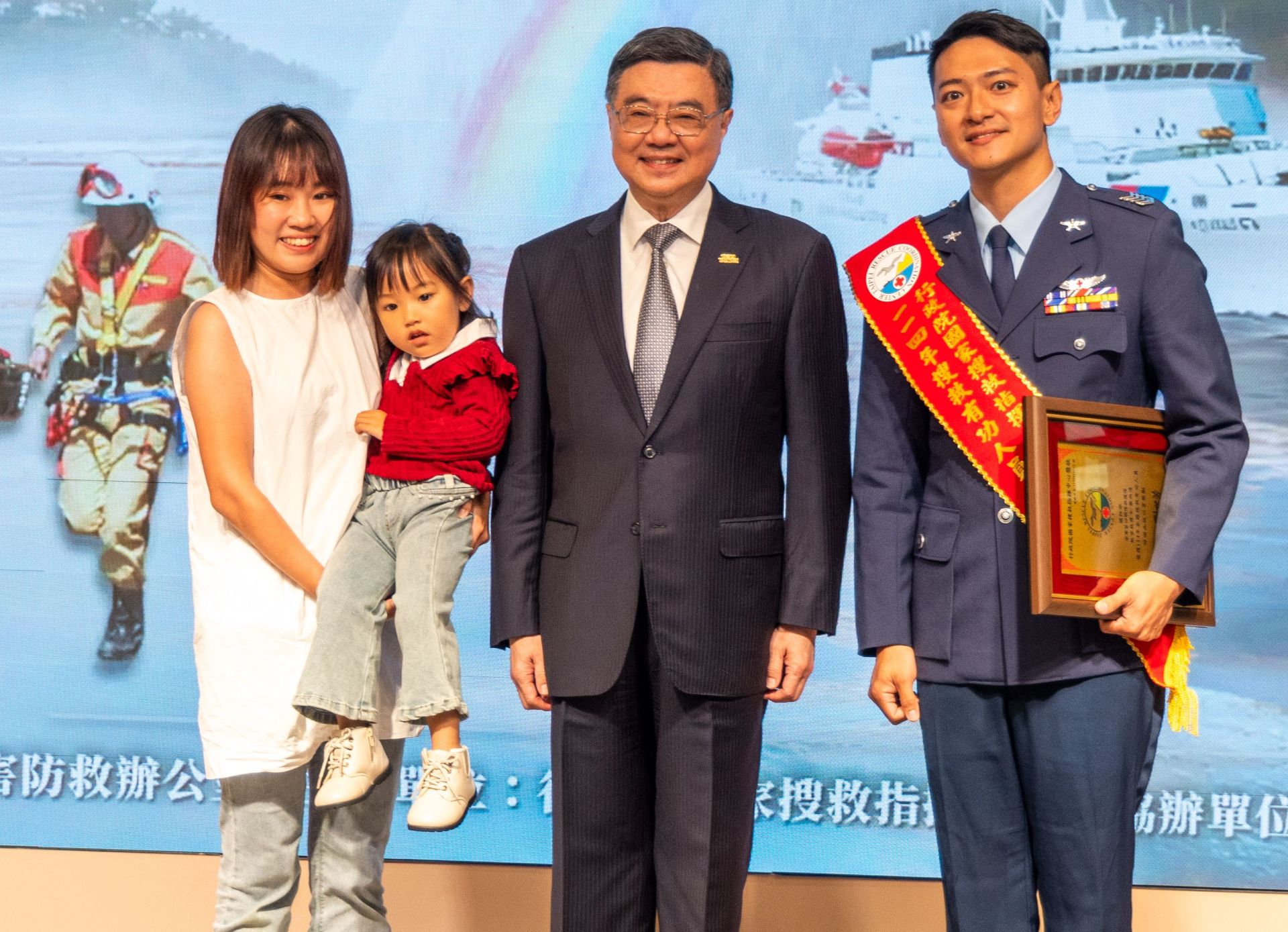 蔡雨達上士榮獲114年搜救有功人員第1類「實際執行搜救任務」獎項，邀請眷屬一同上臺與卓揆合影留念。（記者劉宸瑋攝）