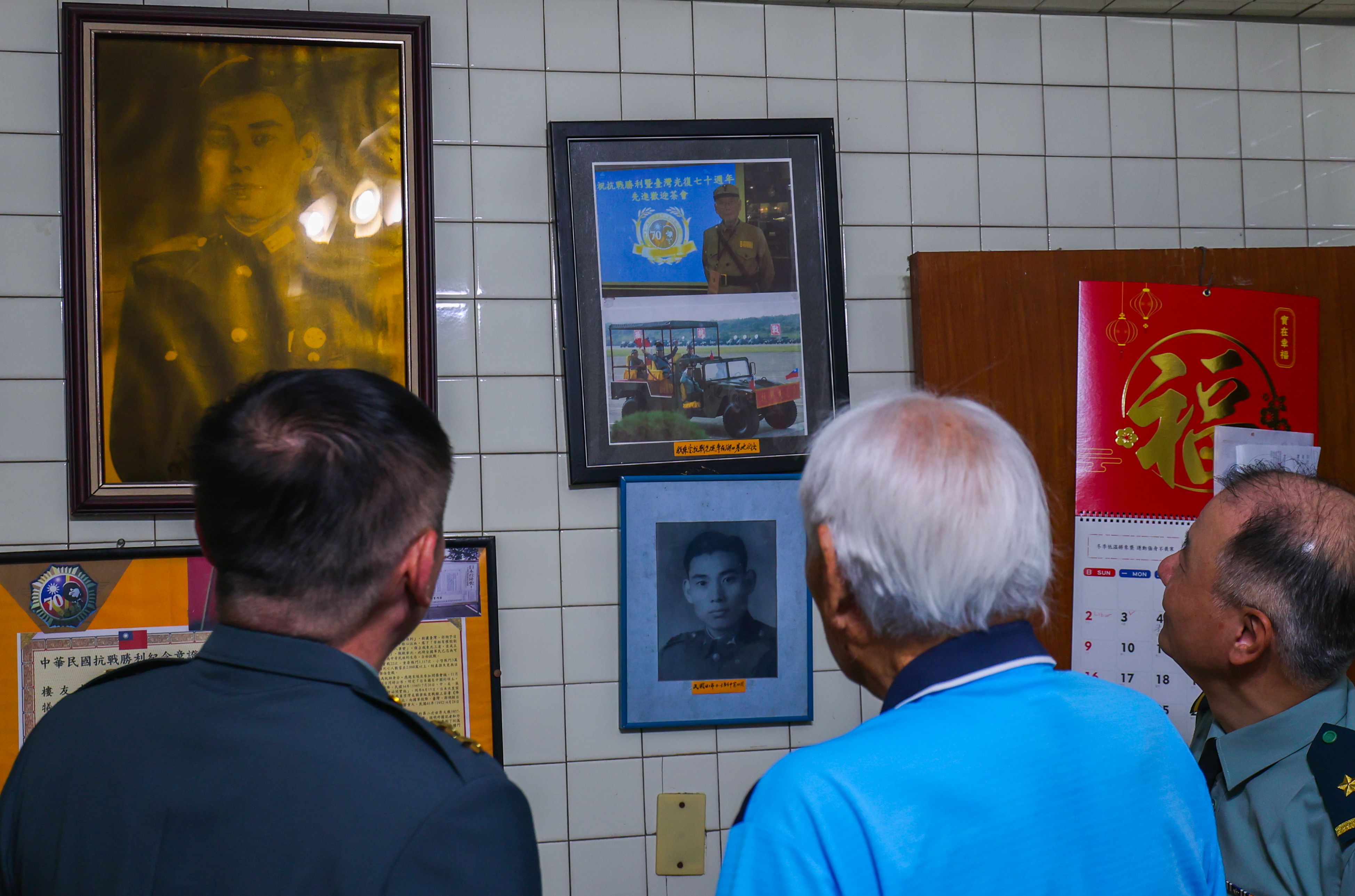 樓友水親自引領劉指揮官等人參觀牆上陳列的歷史相片與珍貴紀錄，包含當年抗戰勝利時所保存的日軍投降書與留影。（記者連琳攝）