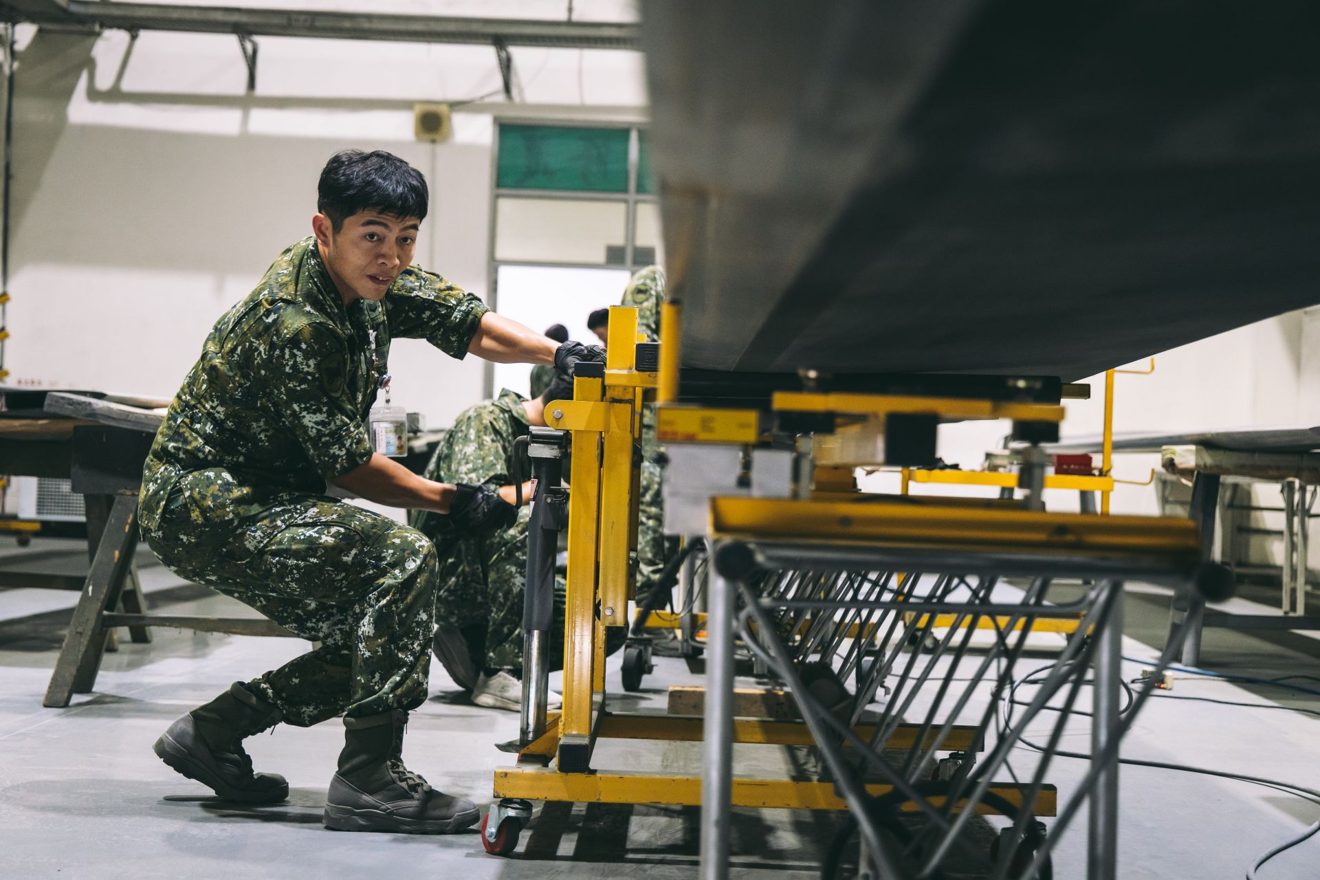  複材配造所官兵運用平衡儀葉片承載車在葉片中心將其撐起，並移至靜態平衡儀上方進行檢測。（記者陳彥陵攝）