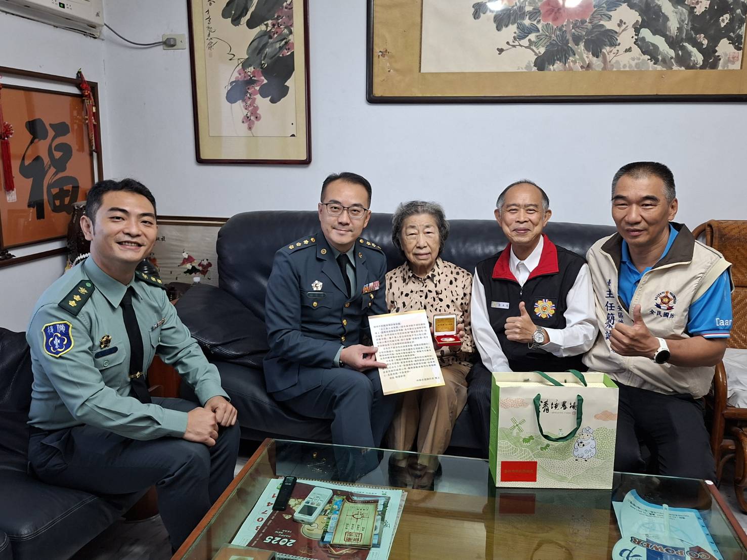 臺北市後備指揮部指揮官顏上校頒贈「紀念二戰暨抗戰勝利80週年紀念徽章」予4位高齡抗戰榮民長輩。（臺北市榮服處提供）