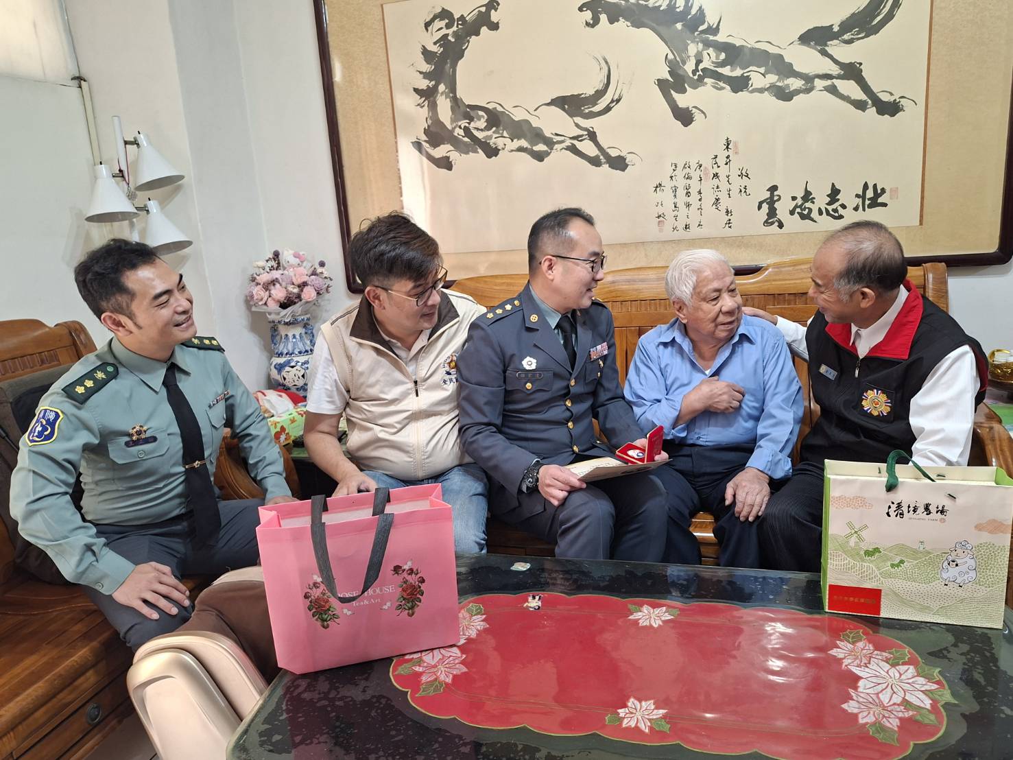 臺北市後備指揮部指揮官顏上校頒贈「紀念二戰暨抗戰勝利80週年紀念徽章」予4位高齡抗戰榮民長輩。（臺北市榮服處提供）