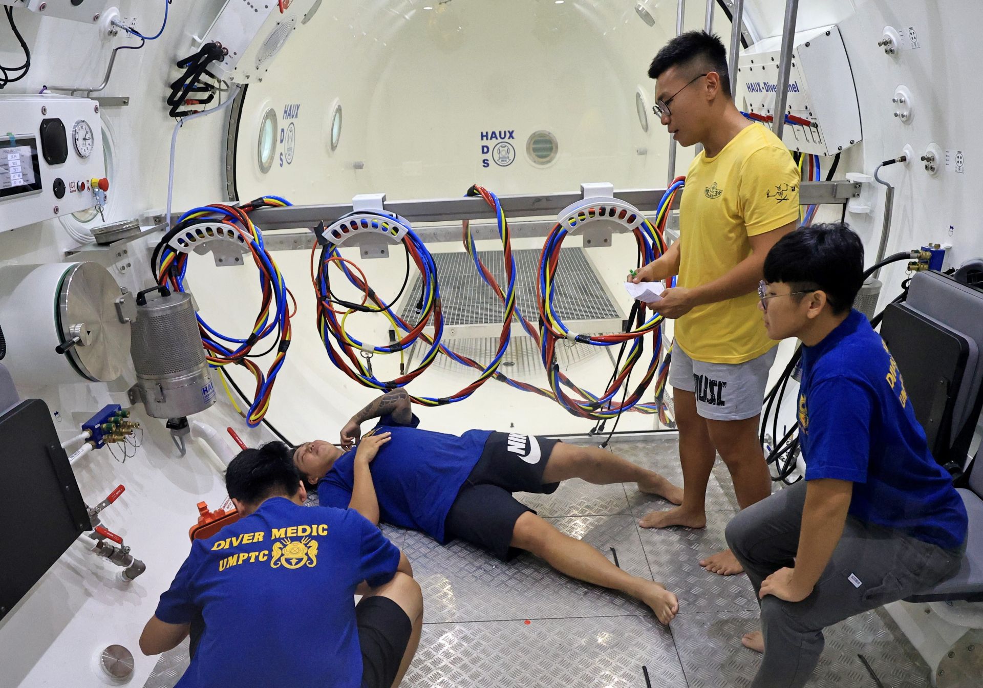  潛水組學員在訓練艙內模擬大量出血，由潛生士進行緊急醫療處置。（本報資料照片）