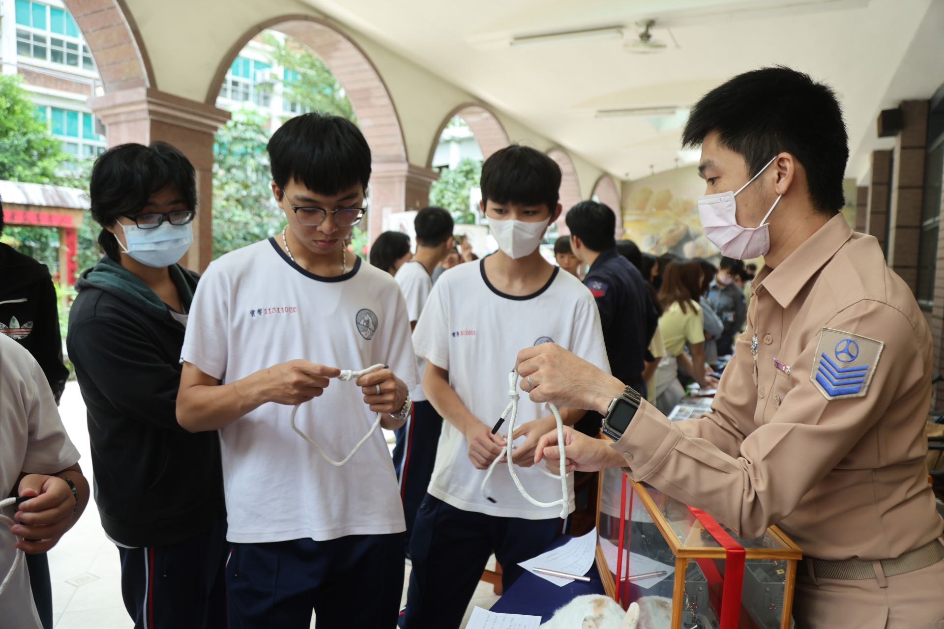 海軍官兵向同學教導常用的繩結結繩技巧。（記者孫建屏攝）