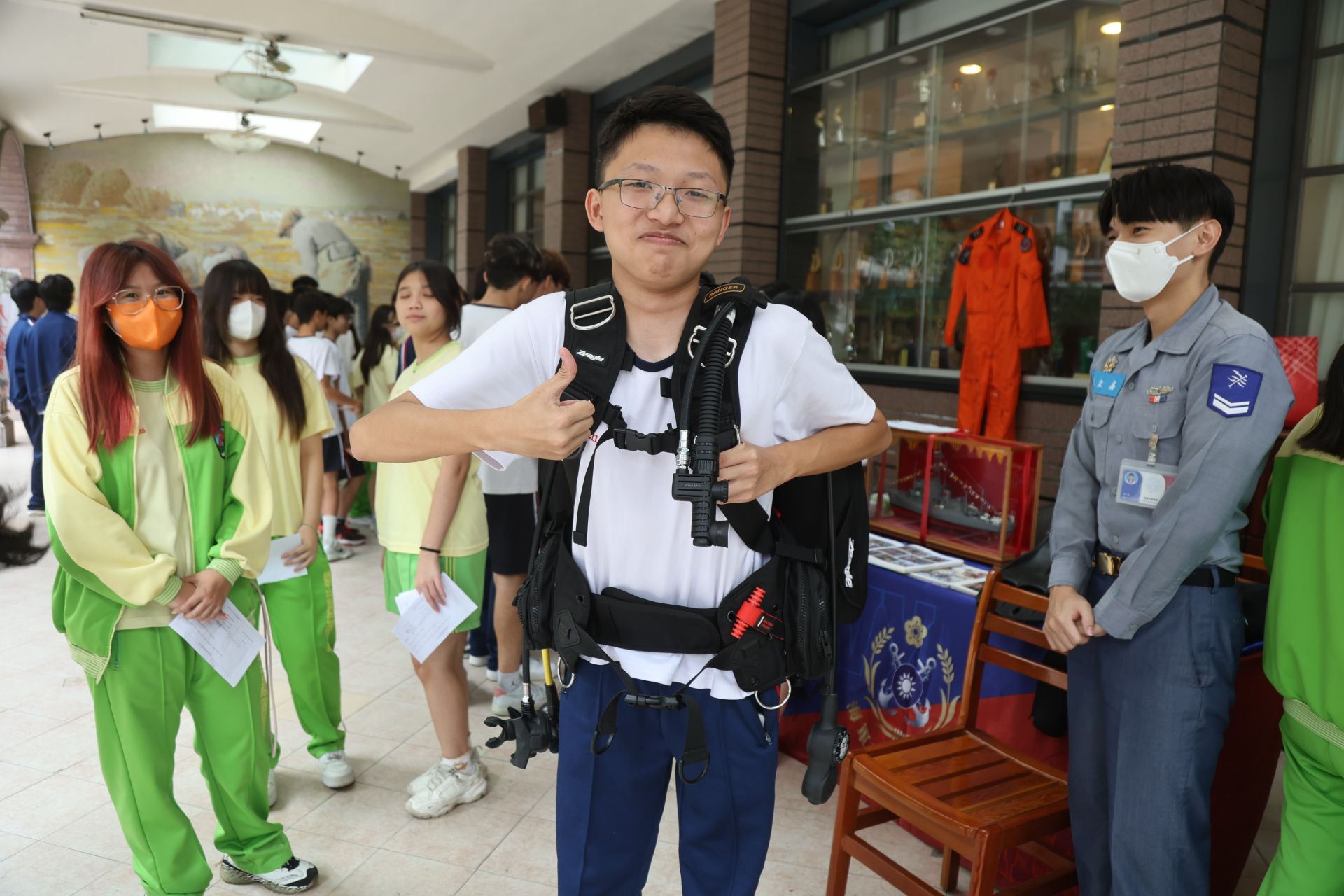 男同學穿重達30公手的潛水裝具，體驗深海潛將的感受。（記者孫建屏攝）