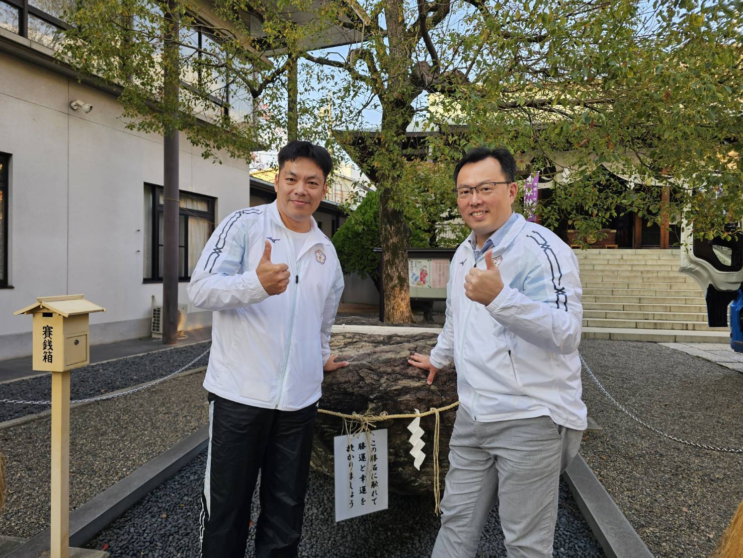 運動部次長鄭世忠（右）與代表團團長林昭穎手摸「勝石」祈福，祝代表團邁向勝利。（運動部提供）