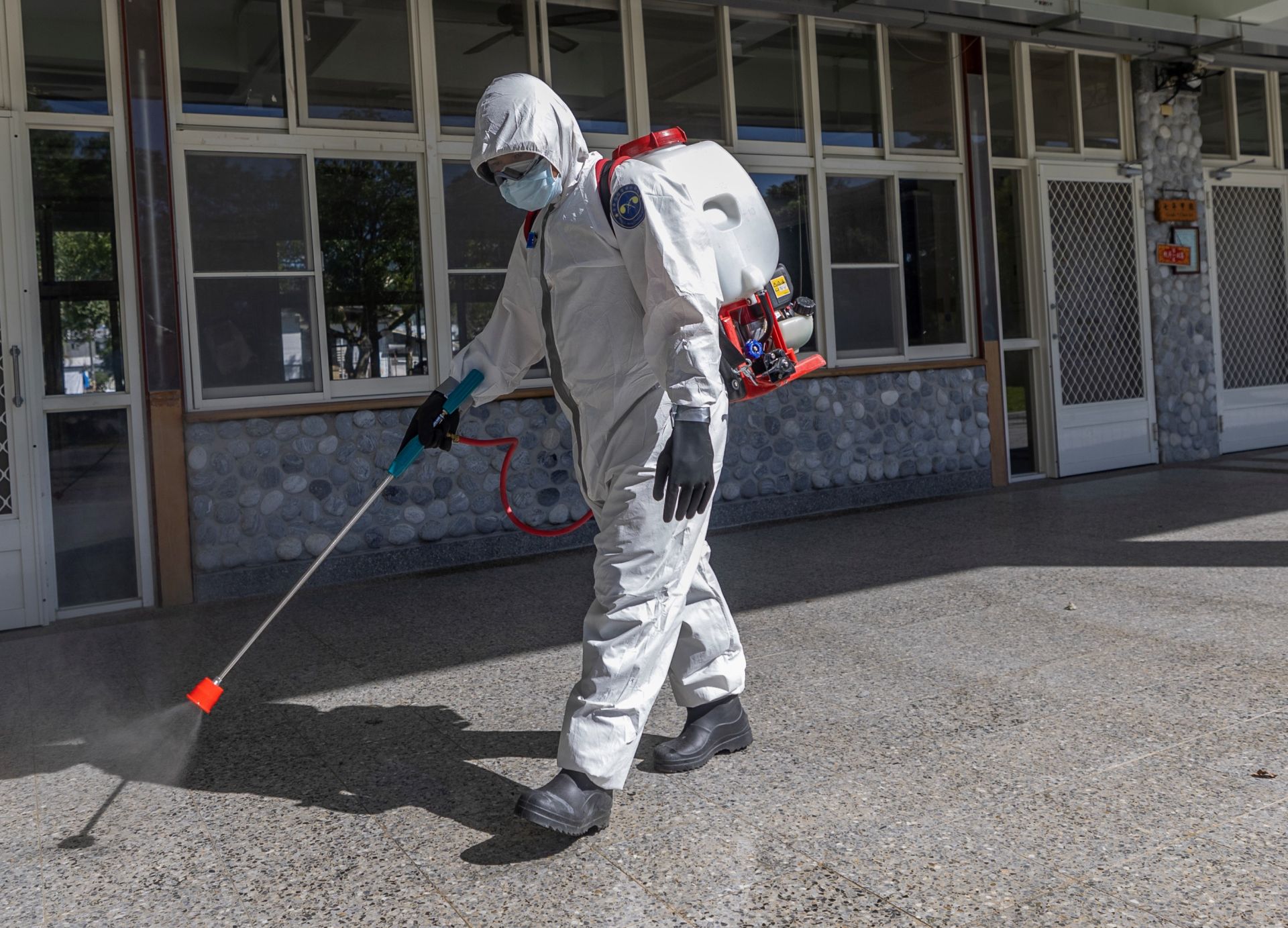 化學兵部隊昨日進入校舍走廊噴灑消毒藥劑，徹底消除潛藏的病菌，讓萬榮國中的師生們，能夠安心返回校園。（記者林睿奕攝）