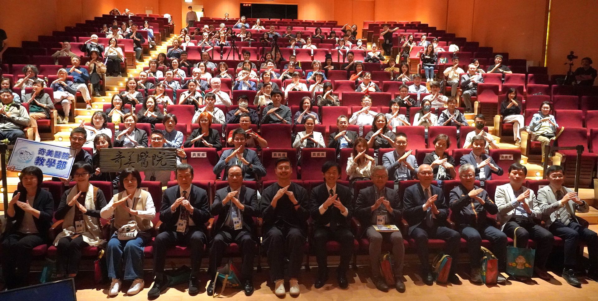 2025「臺灣當代人物論壇」現場，與會貴賓及民眾齊聚合影，並以「人」字手勢展現「以人為本」的精神。（奇美醫院提供）