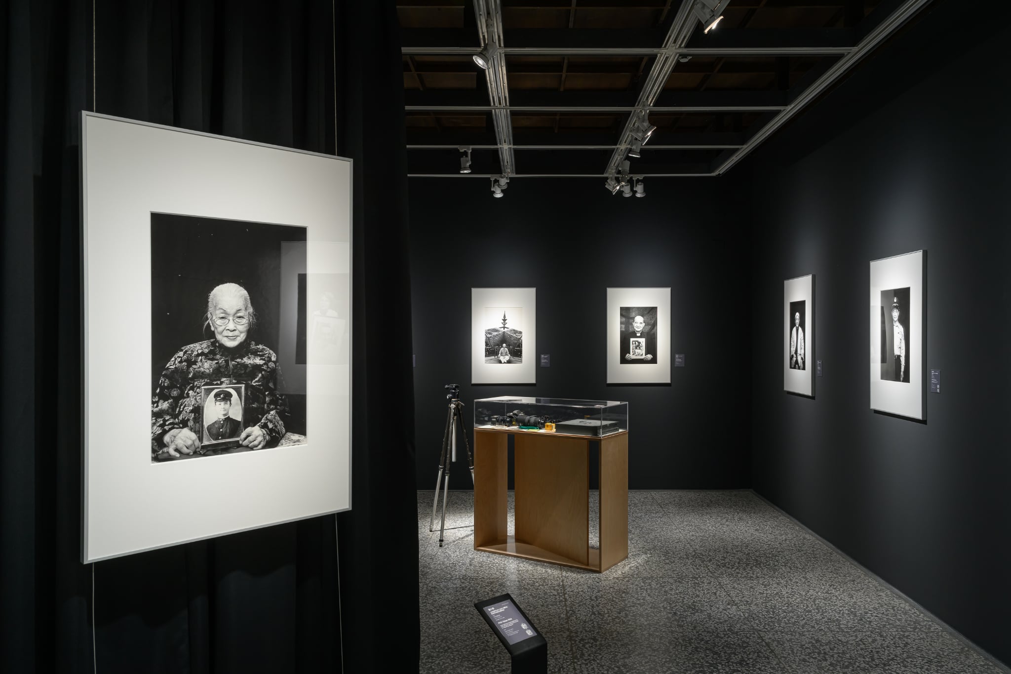 潘小俠《藍張阿冬與先生藍明谷》作品，視覺集中被攝者的神情與手中的肖像，形成觀者無可閃躲的凝視。（攝影中心提供）