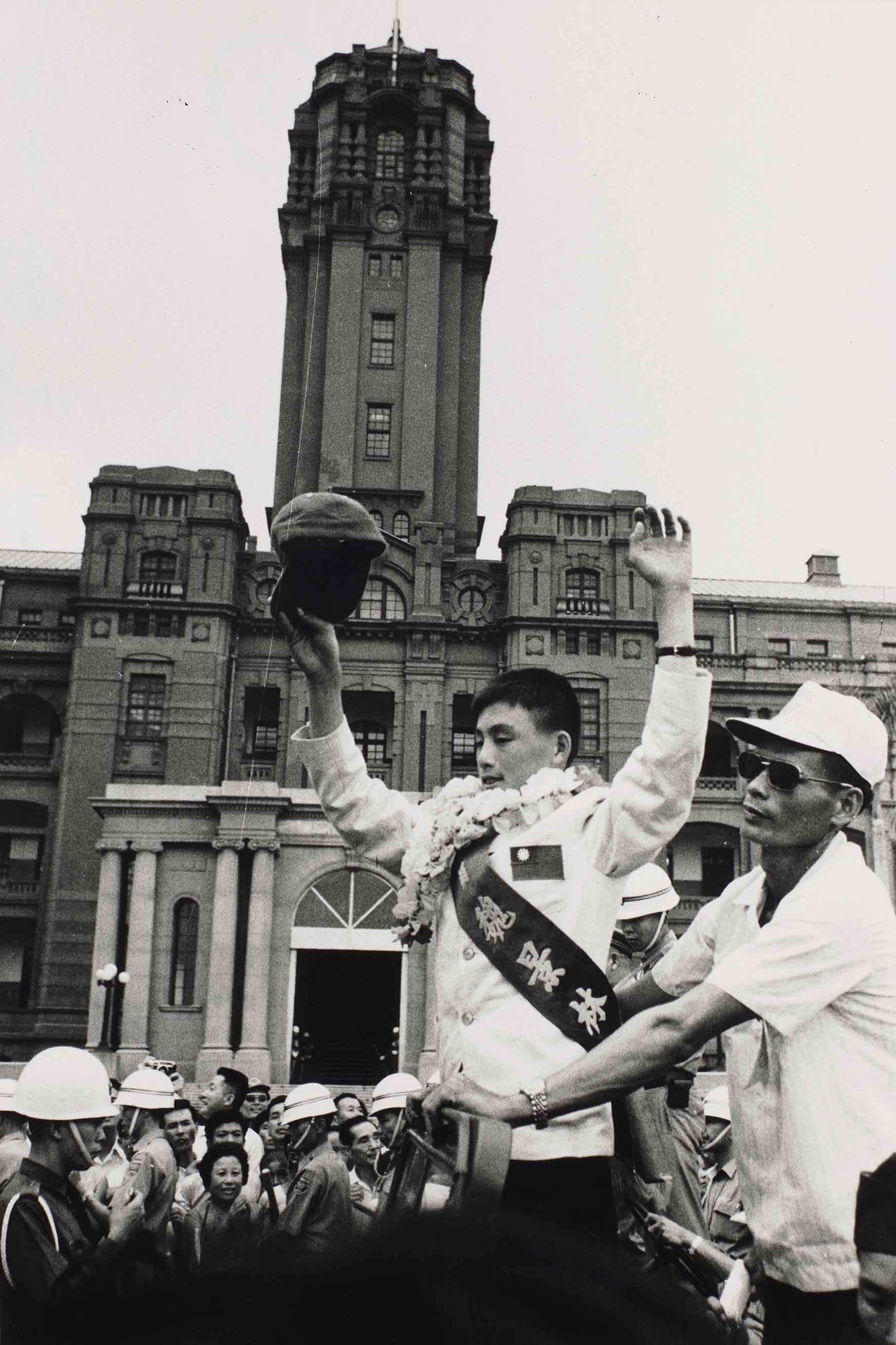 〈小國手魏景林〉 攝影家翁庭華作品，1971年。翁庭華捕抓到總統府高聳建築與小國手魏景林（1958-）的合影，那一瞬間象徵著榮光的片刻、全臺灣人曾經的瘋狂與集體記憶。（國家攝影文化中心提供）