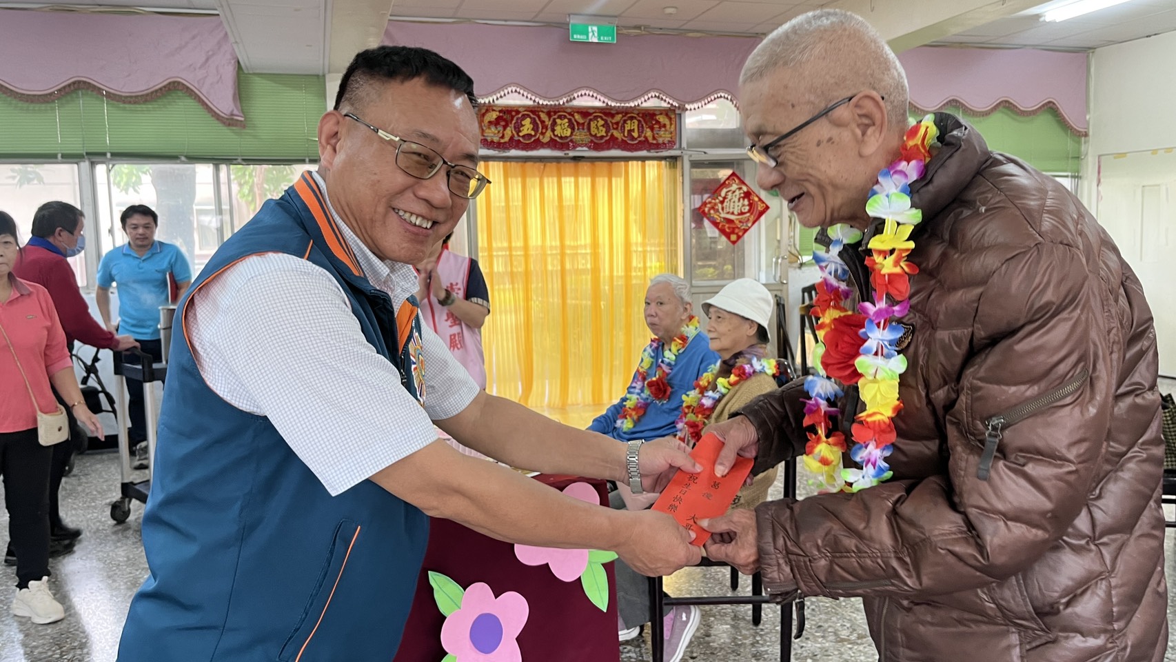 屏東榮家副家主任張立良（左）致贈壽星長輩生日禮物。（屏東榮家提供）