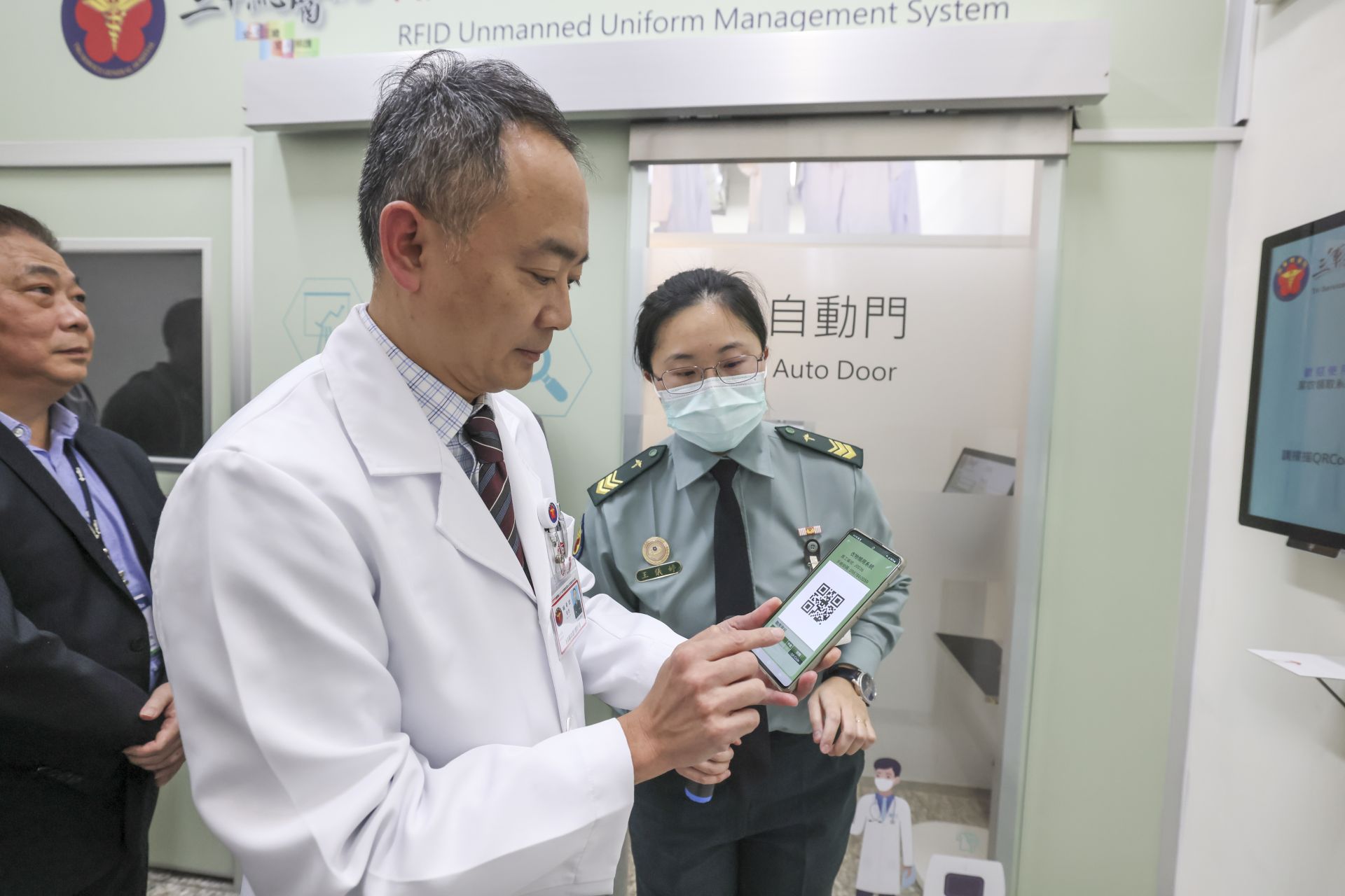  醫護人員透過專屬App掃描QR Code快速完成身分辨識，可自助領取乾淨制服。（記者范瑜攝）