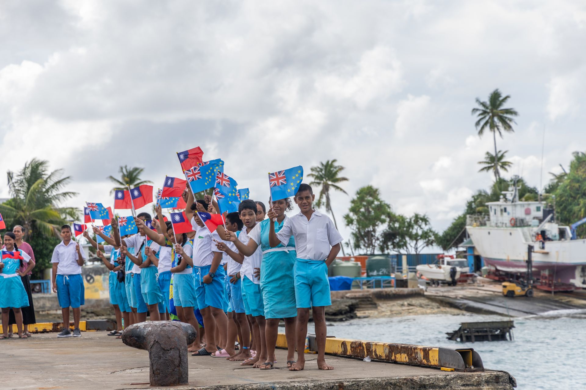  吐瓦魯民眾在港邊揮舞兩國國旗，熱烈歡迎敦睦遠航訓練支隊的到來。（記者林睿奕攝）