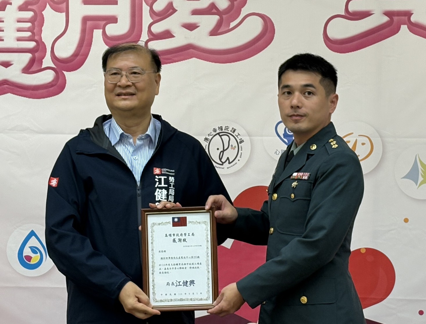 高雄市政府勞工局局長江健興頒贈205廠代表林上校感謝狀，肯定該廠長期支持公益、持續關懷弱勢的貢獻。（205廠提供）