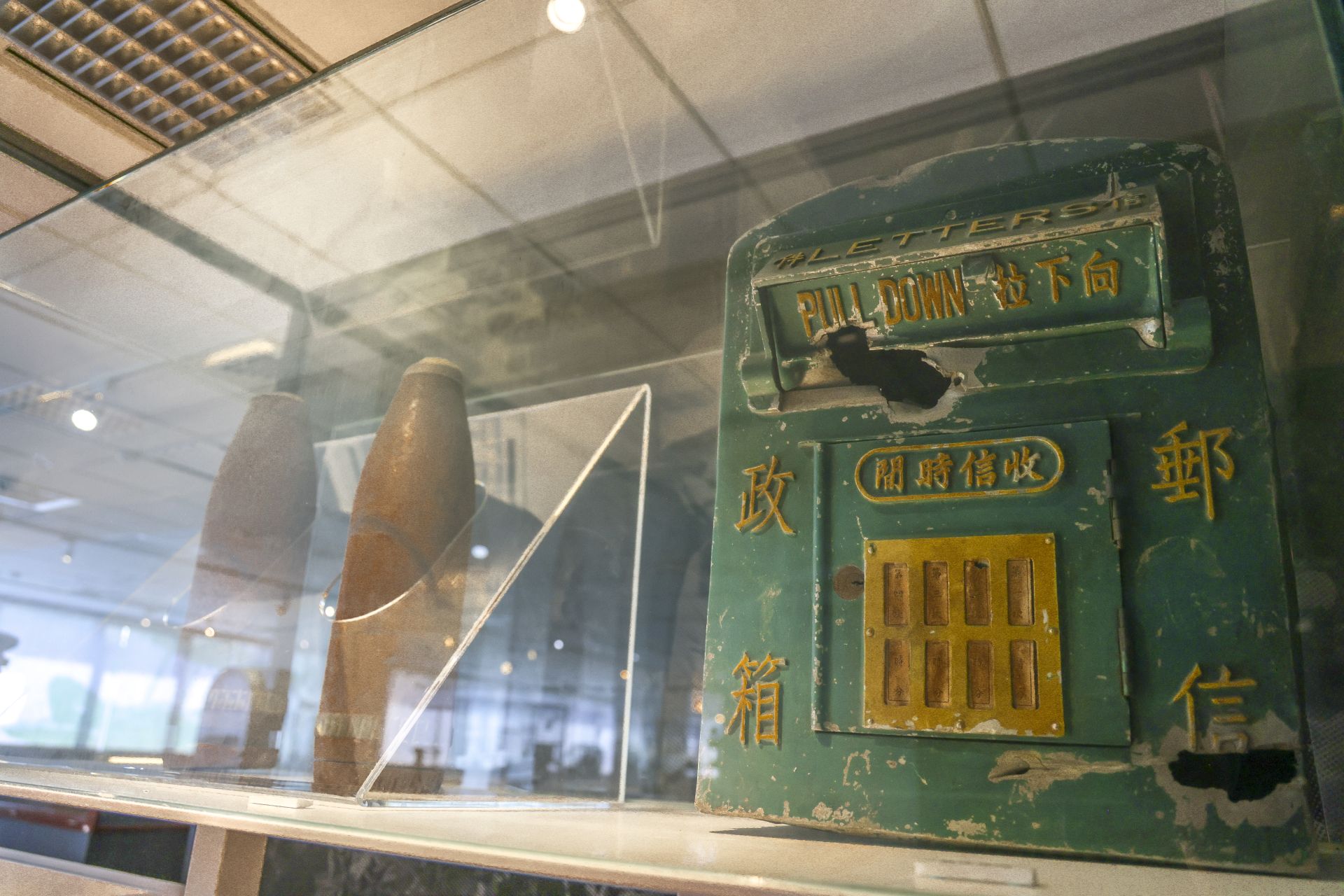 展場中，陳展曾經歷「八二三戰役」，遭砲火轟炸且全臺僅存的郵箱及鏽蝕的砲彈。（記者范瑜攝）