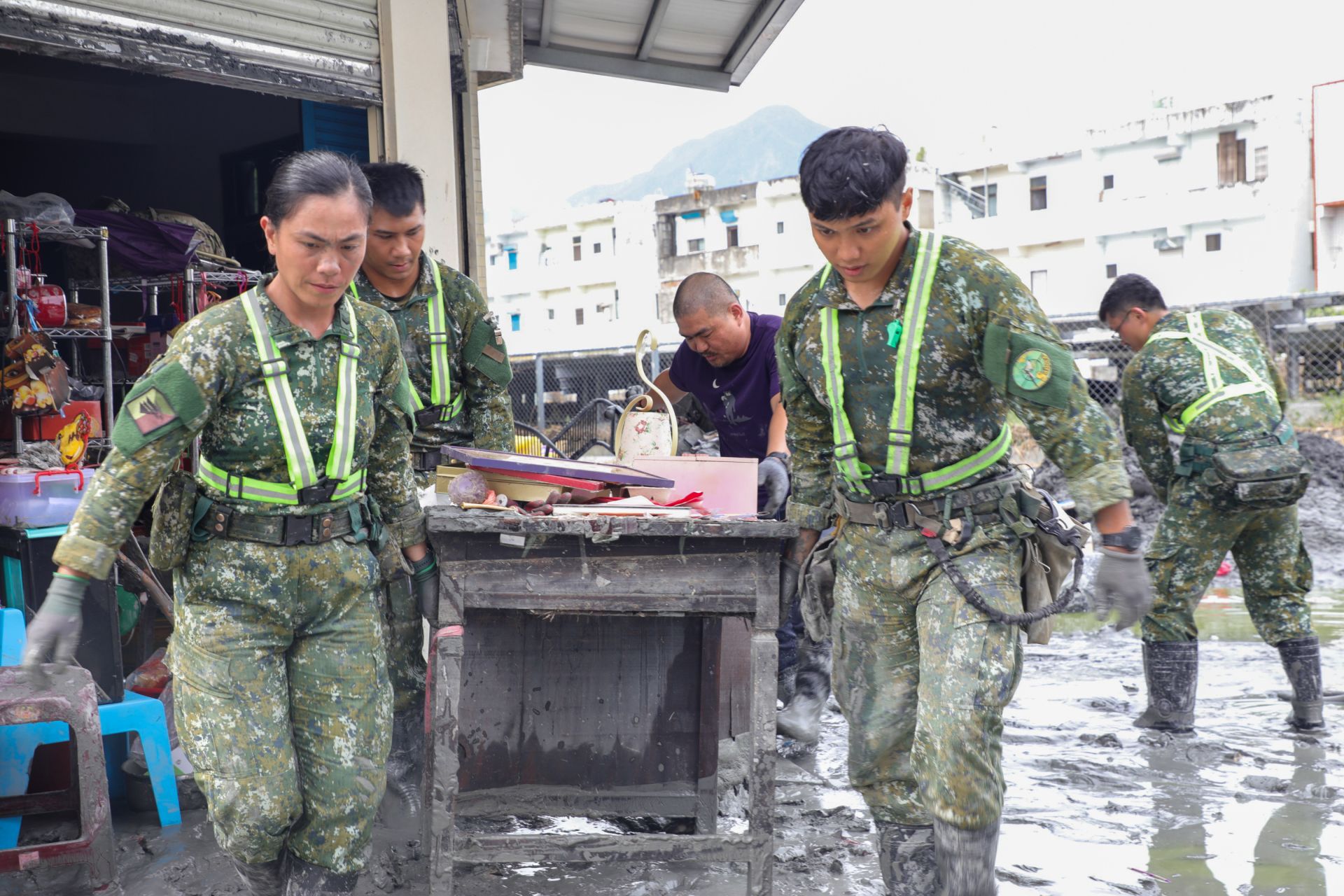 官兵協助民眾共同將廢棄物搬到集中處。（第2作戰區提供）