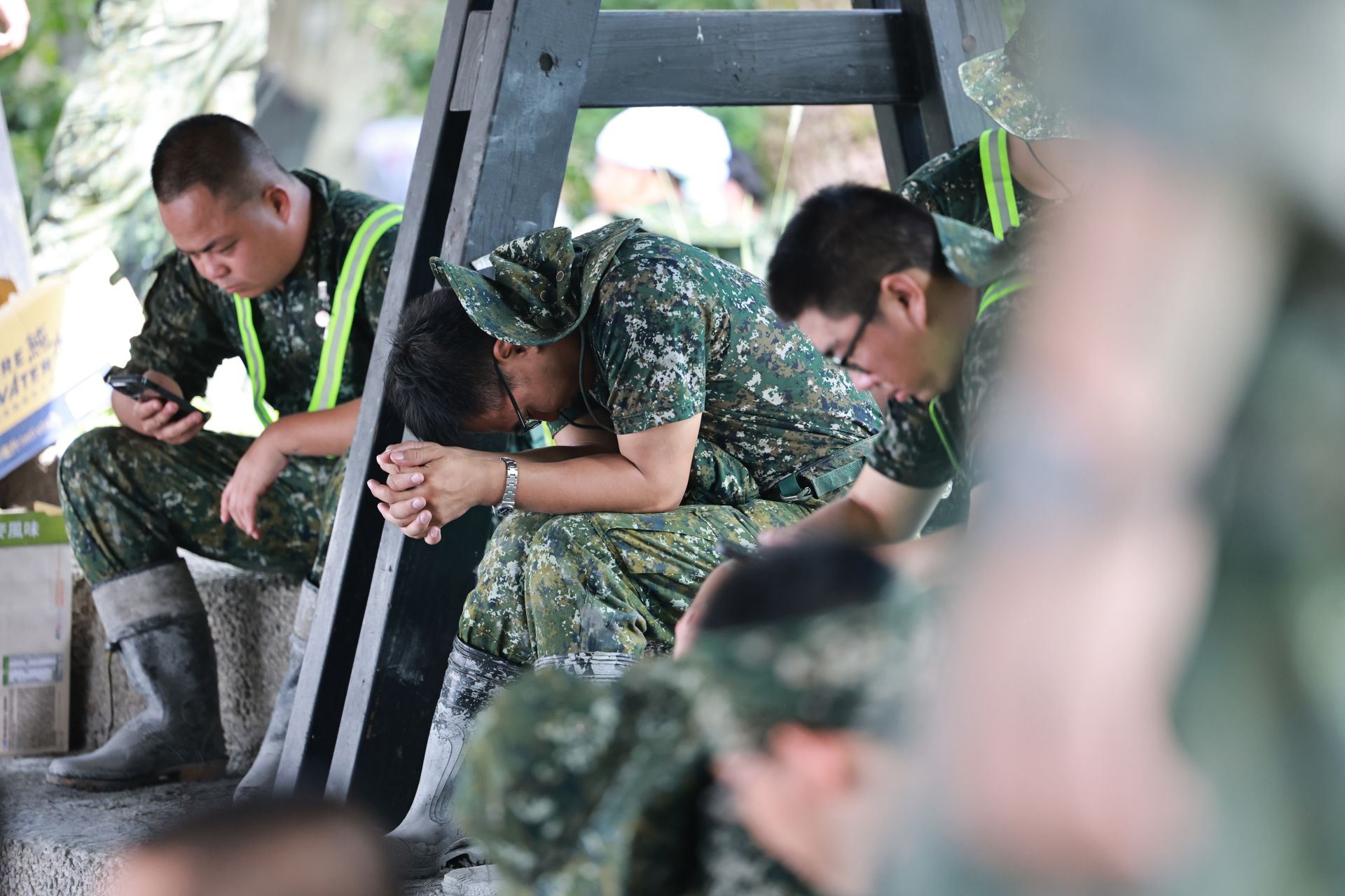  即便沾滿泥濘，官兵在短暫休息後，又迅速投入復原任務。（記者謝承宏攝）