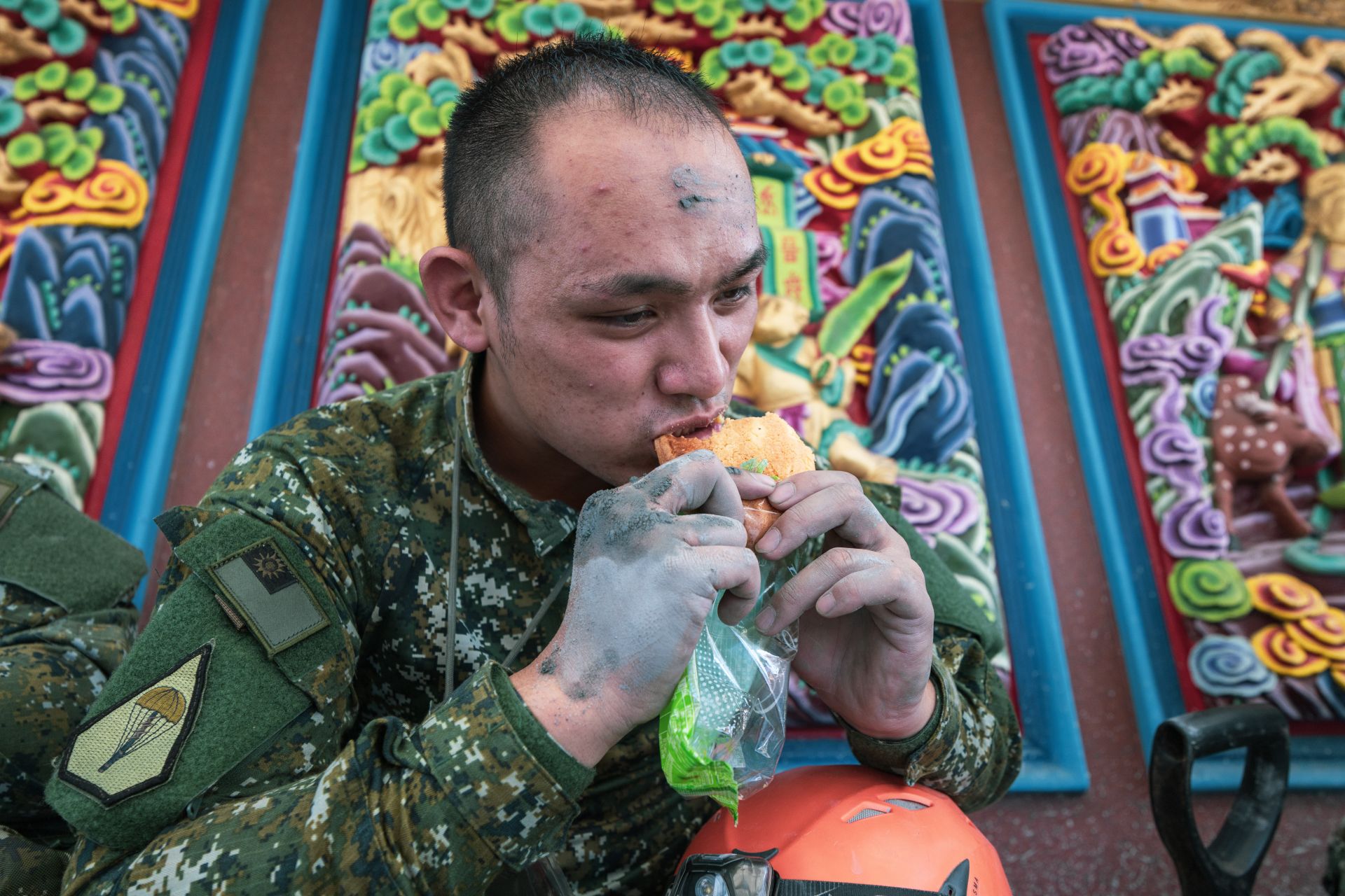  即便沾滿泥濘，官兵在短暫充飢後，又迅速投入復原任務。（記者謝沛宸攝）