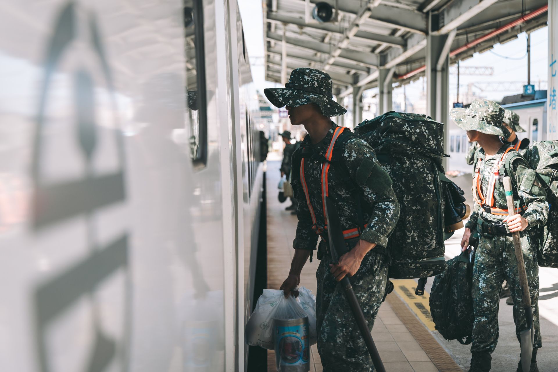 官兵肩負救災裝具與土工器具，有序地登上臺鐵加開專列。（記者陳彥陵攝）