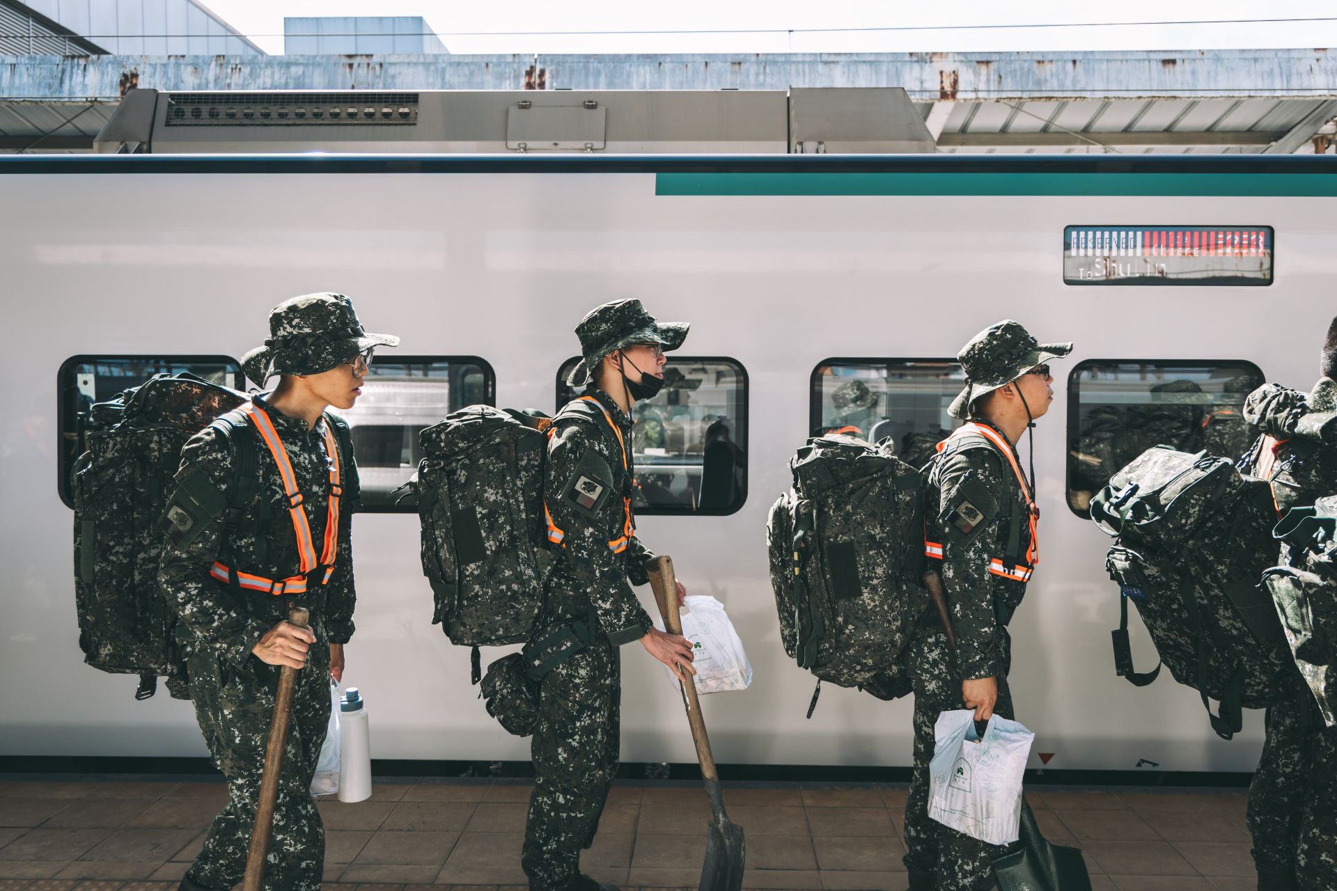 官兵肩負救災裝具與土工器具，有序地登上臺鐵加開專列。（記者陳彥陵攝）