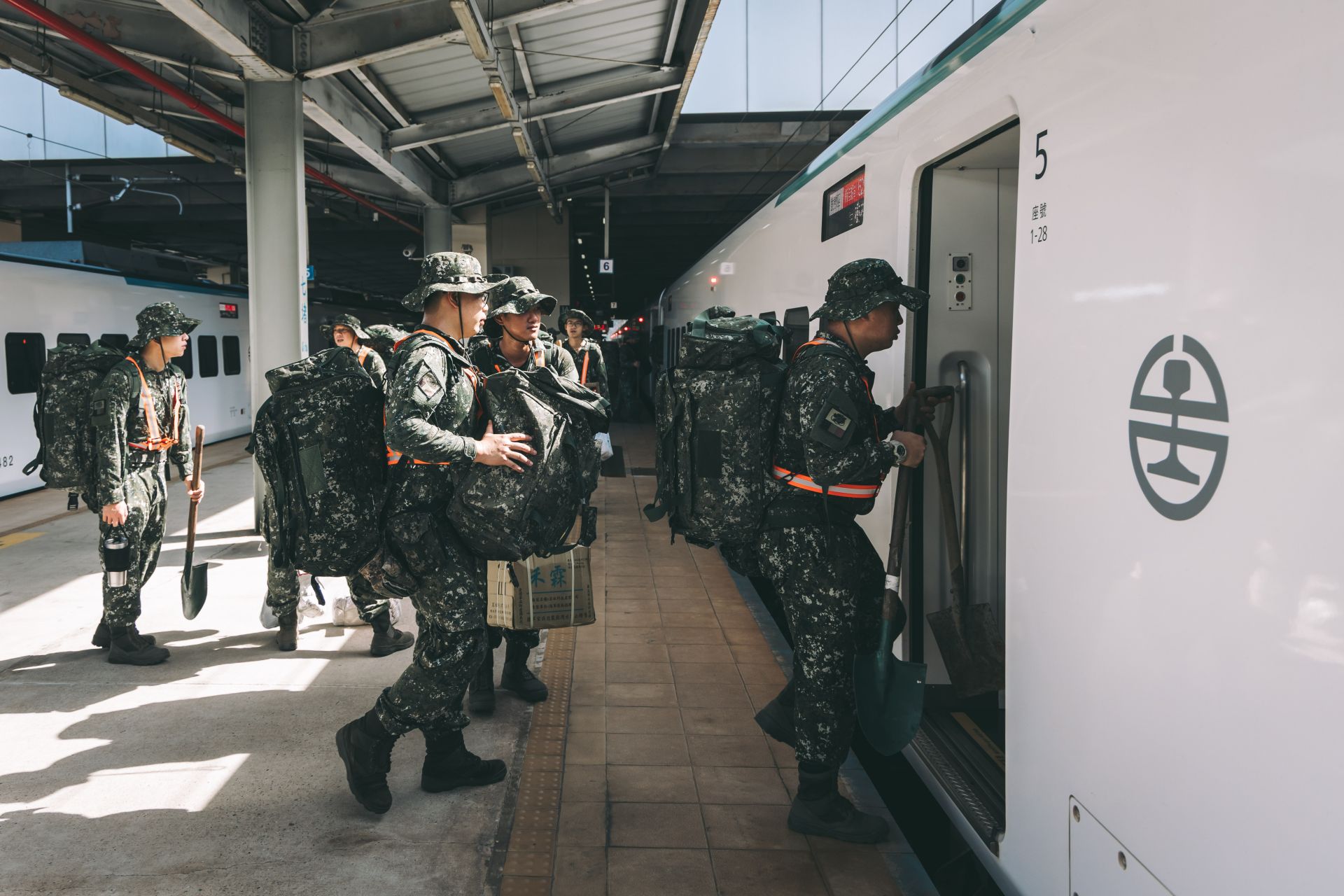 官兵肩負救災裝具與土工器具，有序地登上臺鐵加開專列。（記者陳彥陵攝）