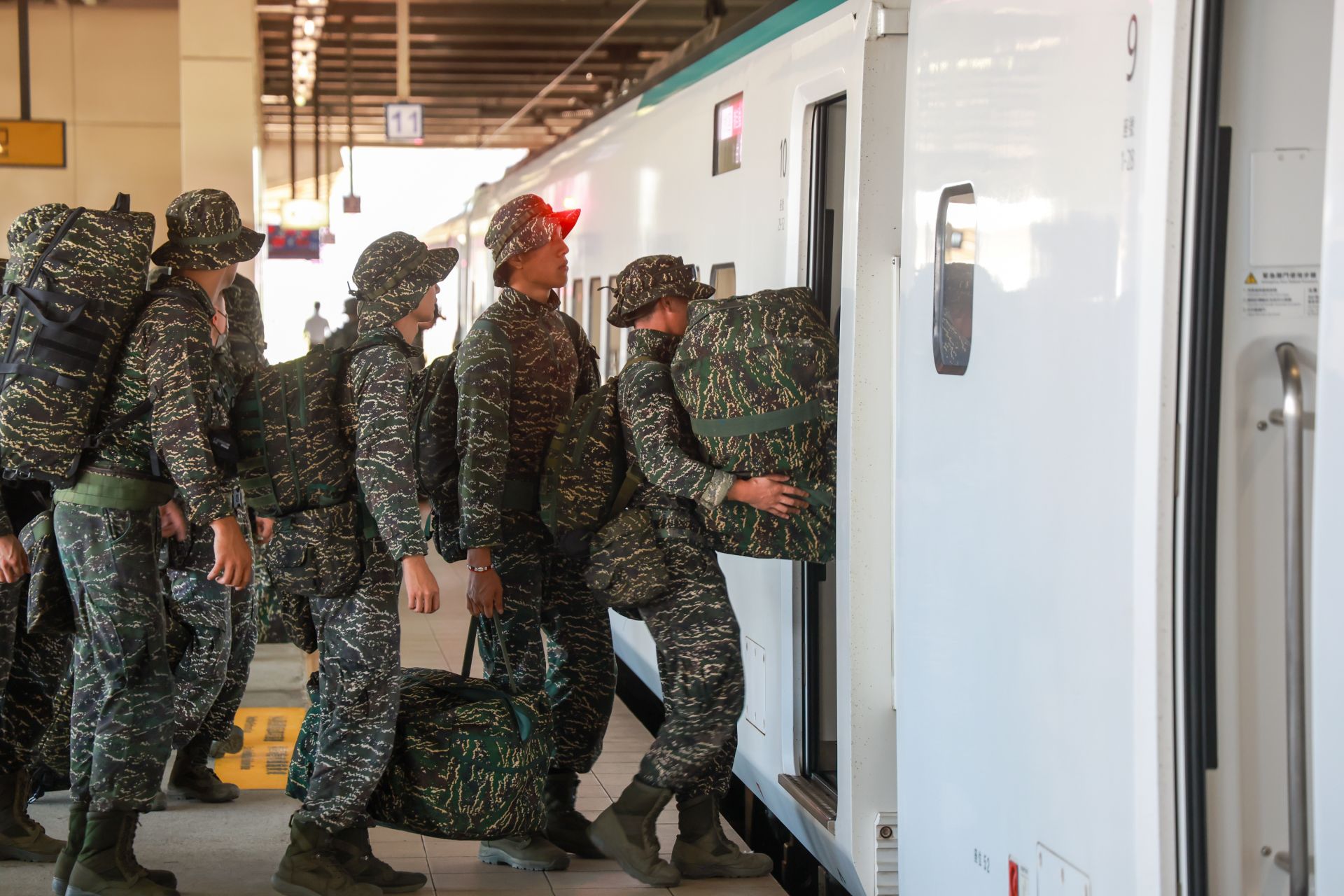 官兵肩負救災裝具與土工器具，有序地登上臺鐵加開專列。（記者葉軒瑜攝）