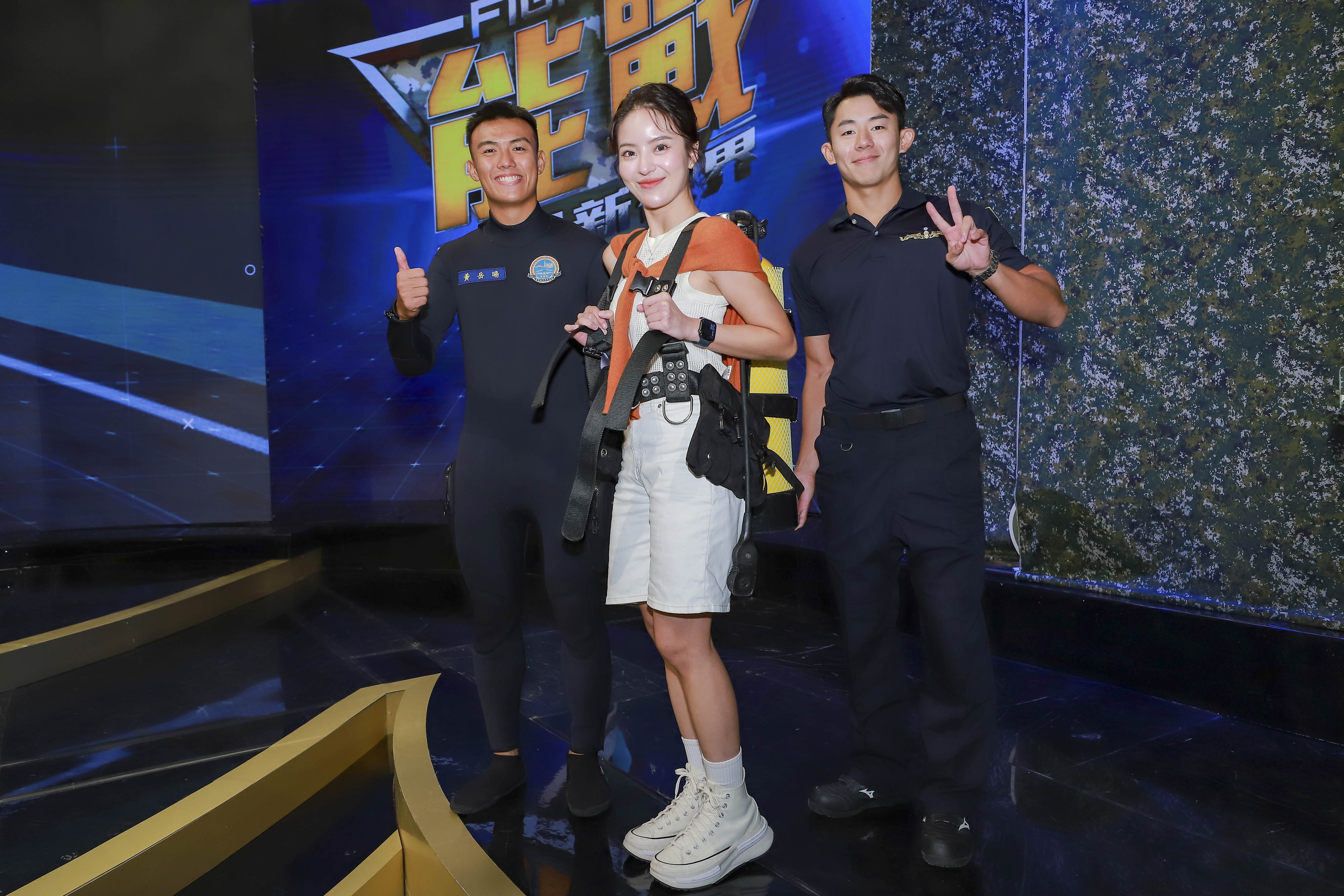 宜芳（中）背上16公斤水肺裝備，首次感受水下作業大隊的真實重量。（民視提供）