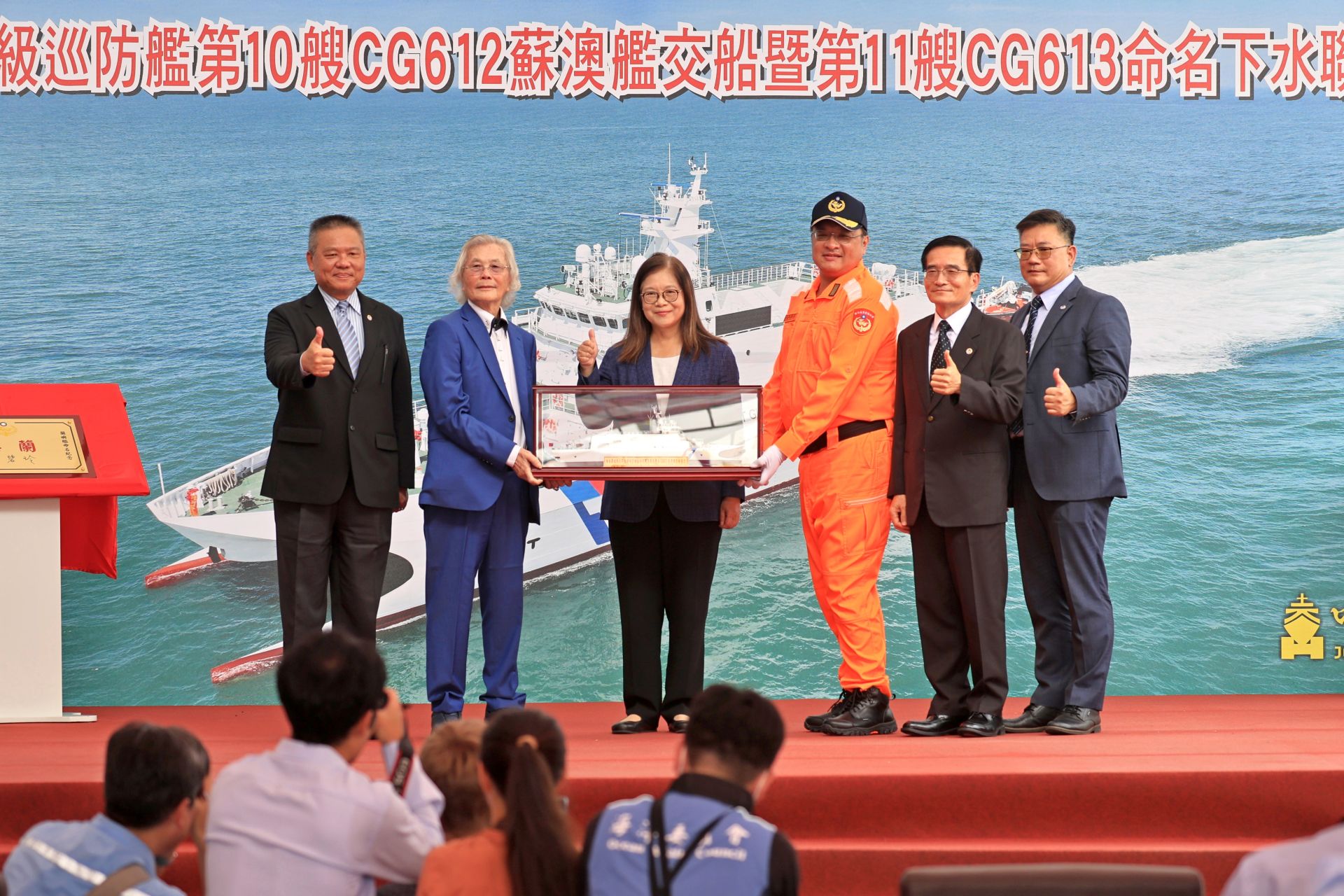 在海委會主委管碧玲等人見證下，中信造船公司董事長韓碧祥致贈CG612蘇澳艦船模，象徵完成交船儀式。（記者孫建屏攝）