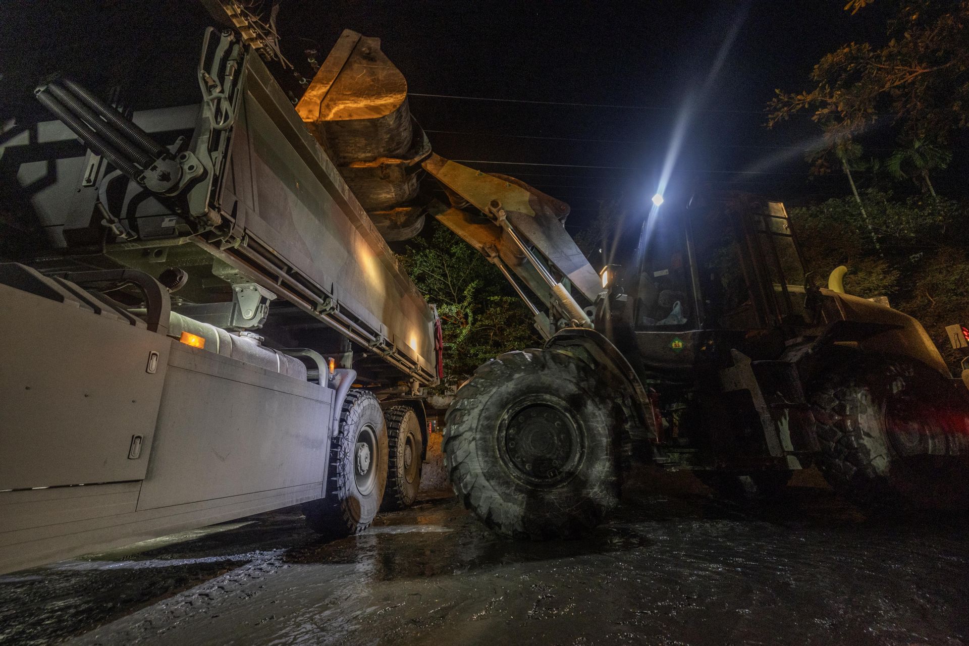  昨日是中秋連假首日，為加速災區復原速度，國軍持續投入兵力協助清淤、消毒與搬運大型廢棄物，夜間則由工兵部隊運用傾卸車等重型機具，接力進行街道淤泥清運，日以繼夜執行災後復原任務，全力協助居民恢復正常生活。（記者林睿奕攝）