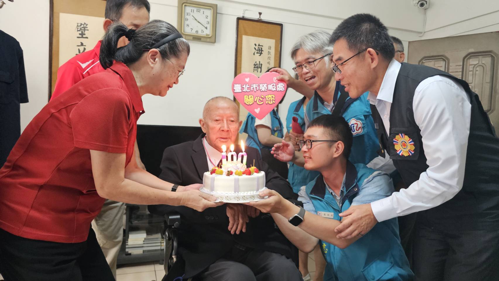 鍾爺爺在家人、學生與榮欣志工、社區服務組長陪伴下，齊唱〈黃埔祝壽歌〉與〈生日快樂歌〉，在溫馨喜樂的氣氛中，共度百歲壽辰。（臺北市榮服處提供）