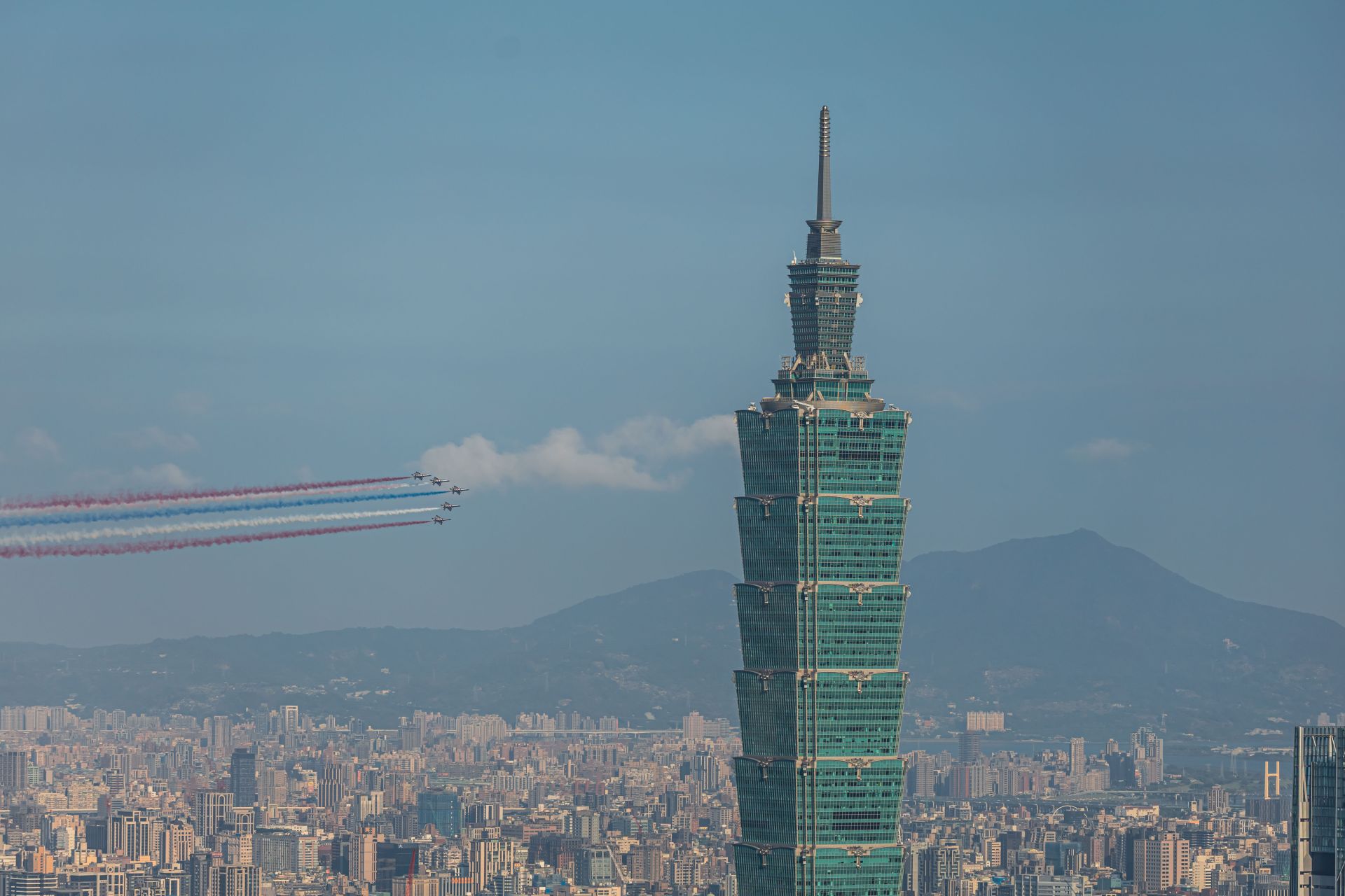  勇鷹高教機5機編隊，施放3色彩煙由總統府向臺北101方向快速通過。（記者謝沛宸攝）