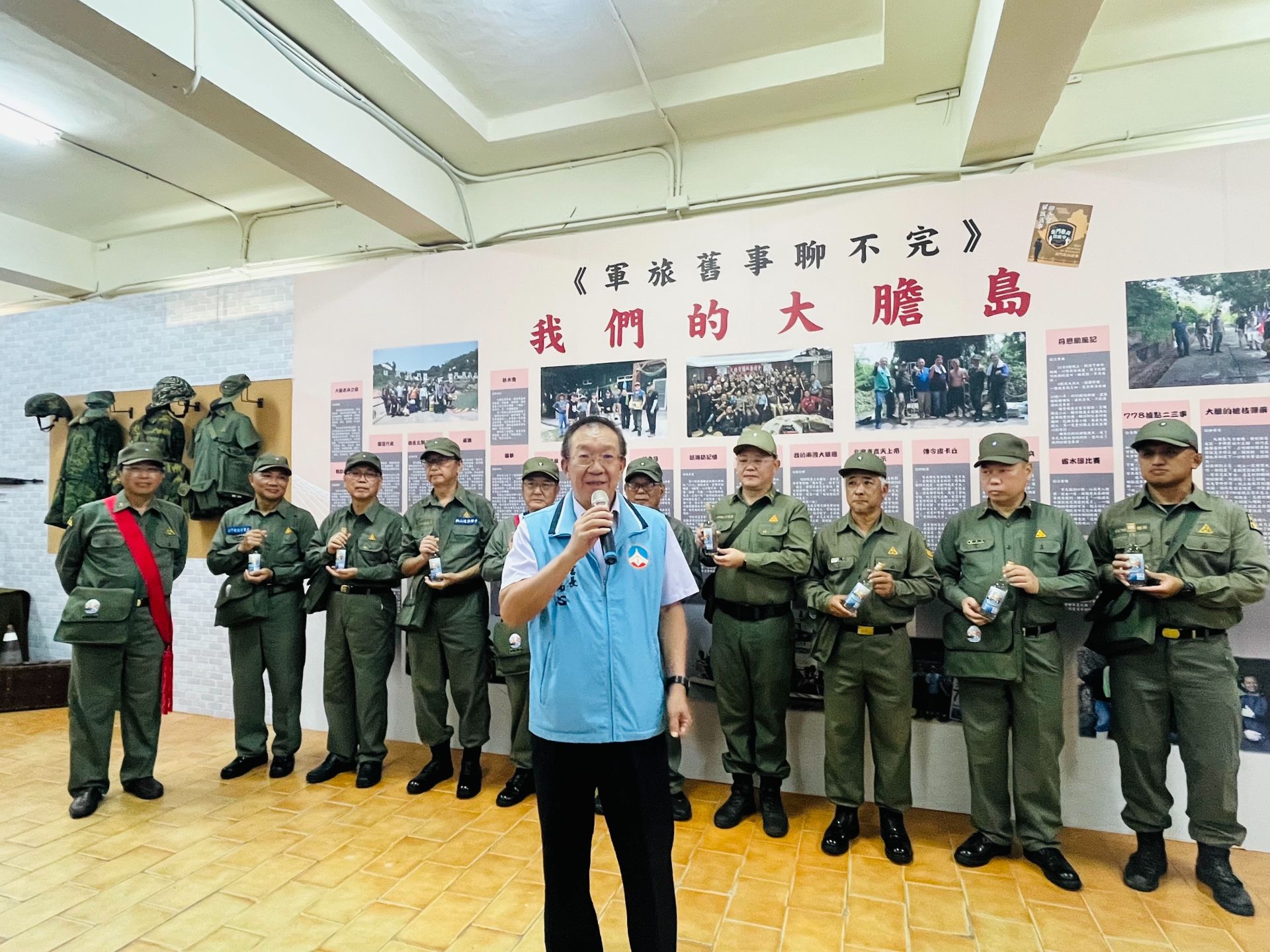 2025金門老兵召集令日昨於金湖鎮「新市256」舉行「老兵故事主題館啟用茶會」，為期兩個半月的系列活動正式啟動，縣府秘書長張瑞心（中）代表縣長陳福海出席，歡迎老兵返金。（金門縣政府提供） 