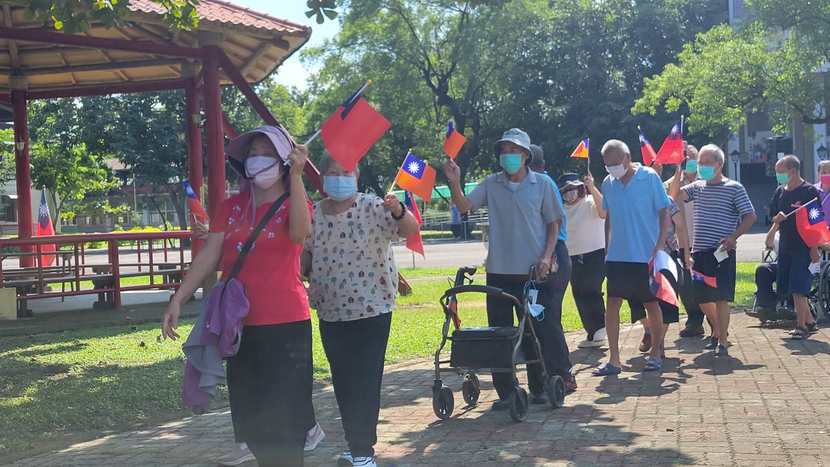 參與健步的住民長輩們手持國旗，健步繞行榮家，展現健康與活力。（屏東榮家提供）