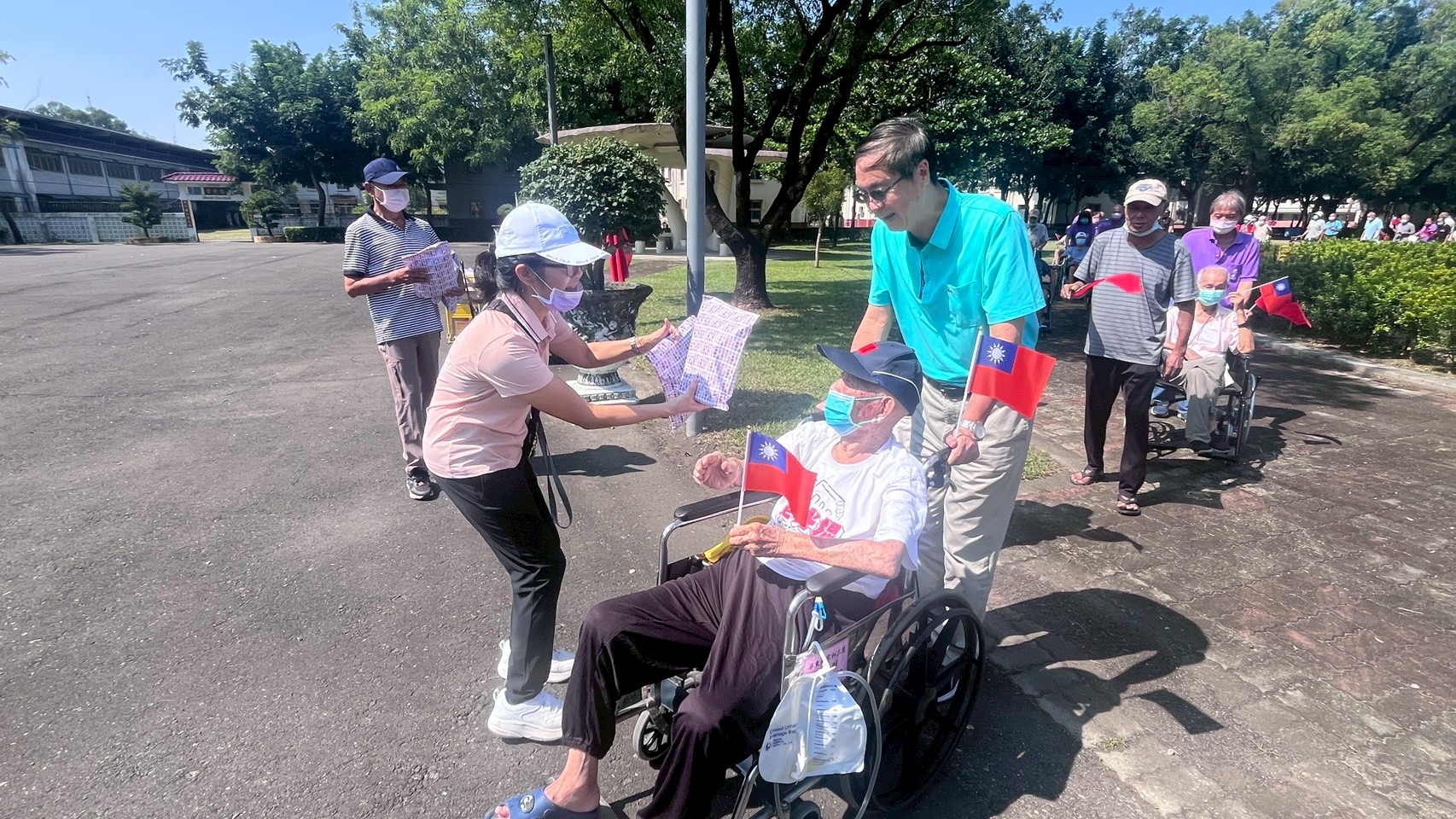 參與健步的住民長輩們手持國旗，健步繞行榮家，展現健康與活力。（屏東榮家提供）