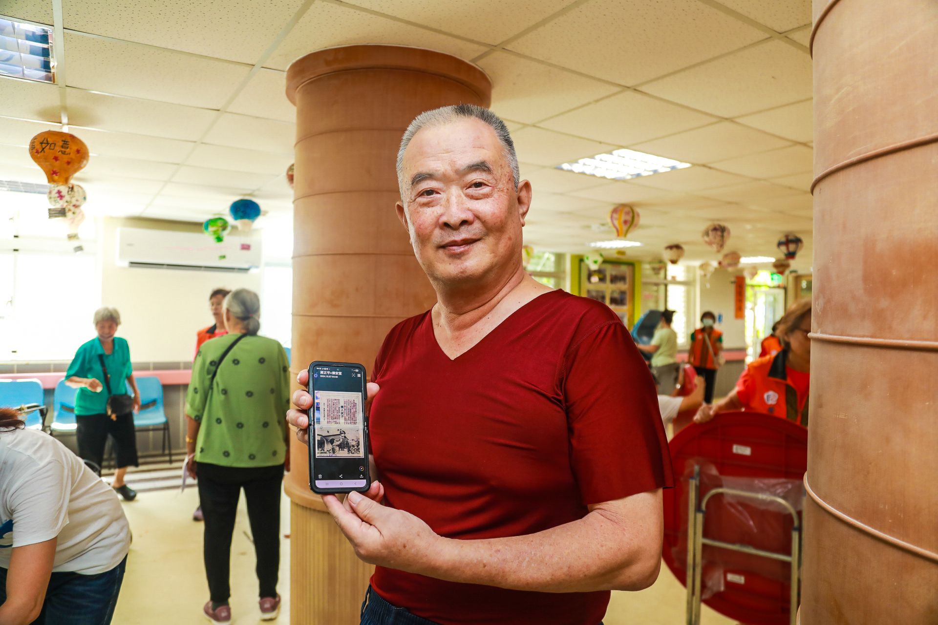  榮民蔣正平展示民國66年登上《青年戰士報》的珍貴照片，分享在臺上擔任標兵時的回憶。（記者李采霖攝）