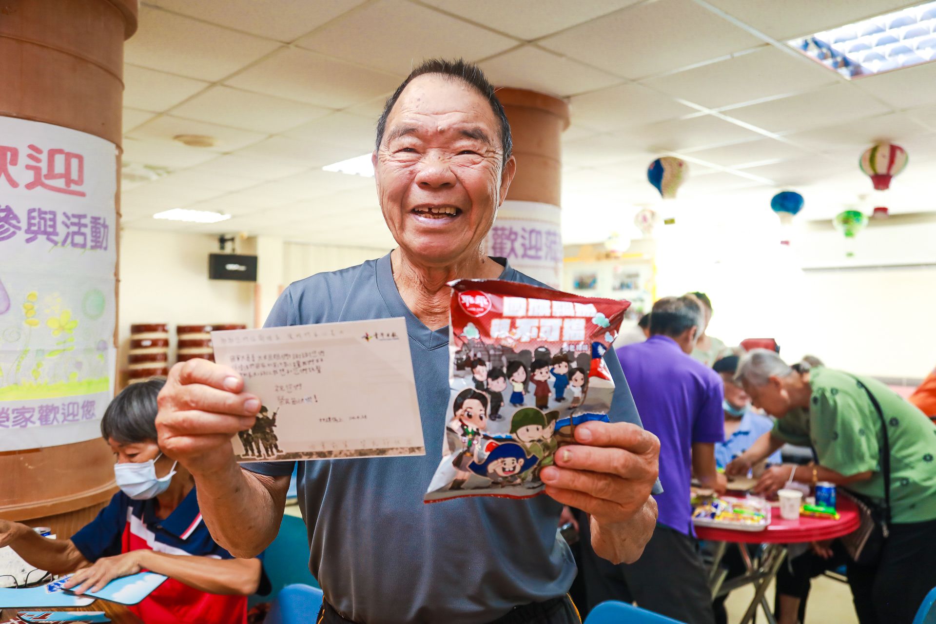 榮民王茂盛開心參與帶動唱與文創拼圖活動，笑著分享服役回憶。（記者李采霖攝）