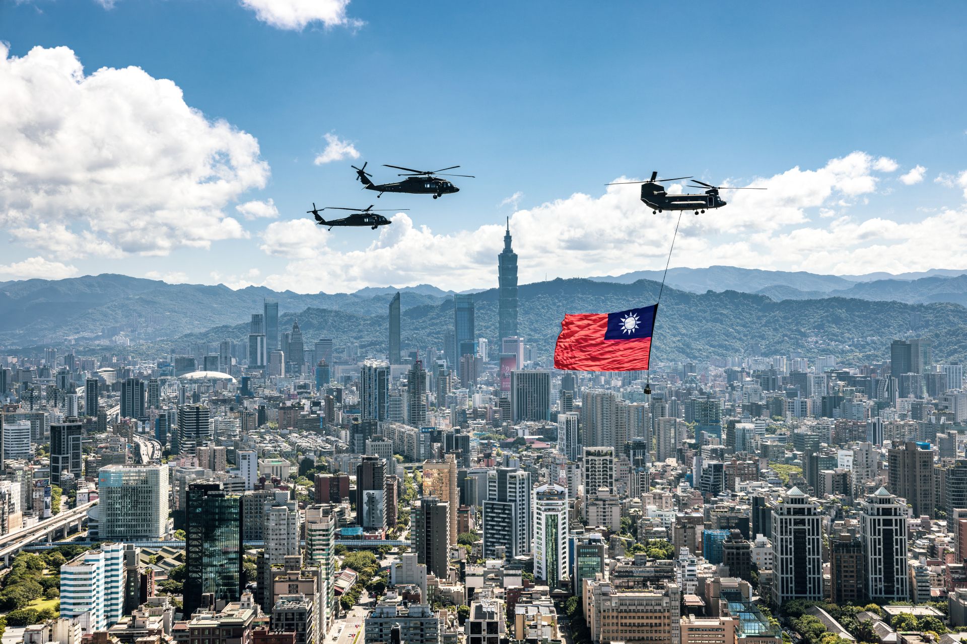  CH-47SD運輸直升機吊掛國旗經過台北101上空。（記者謝承宏攝）