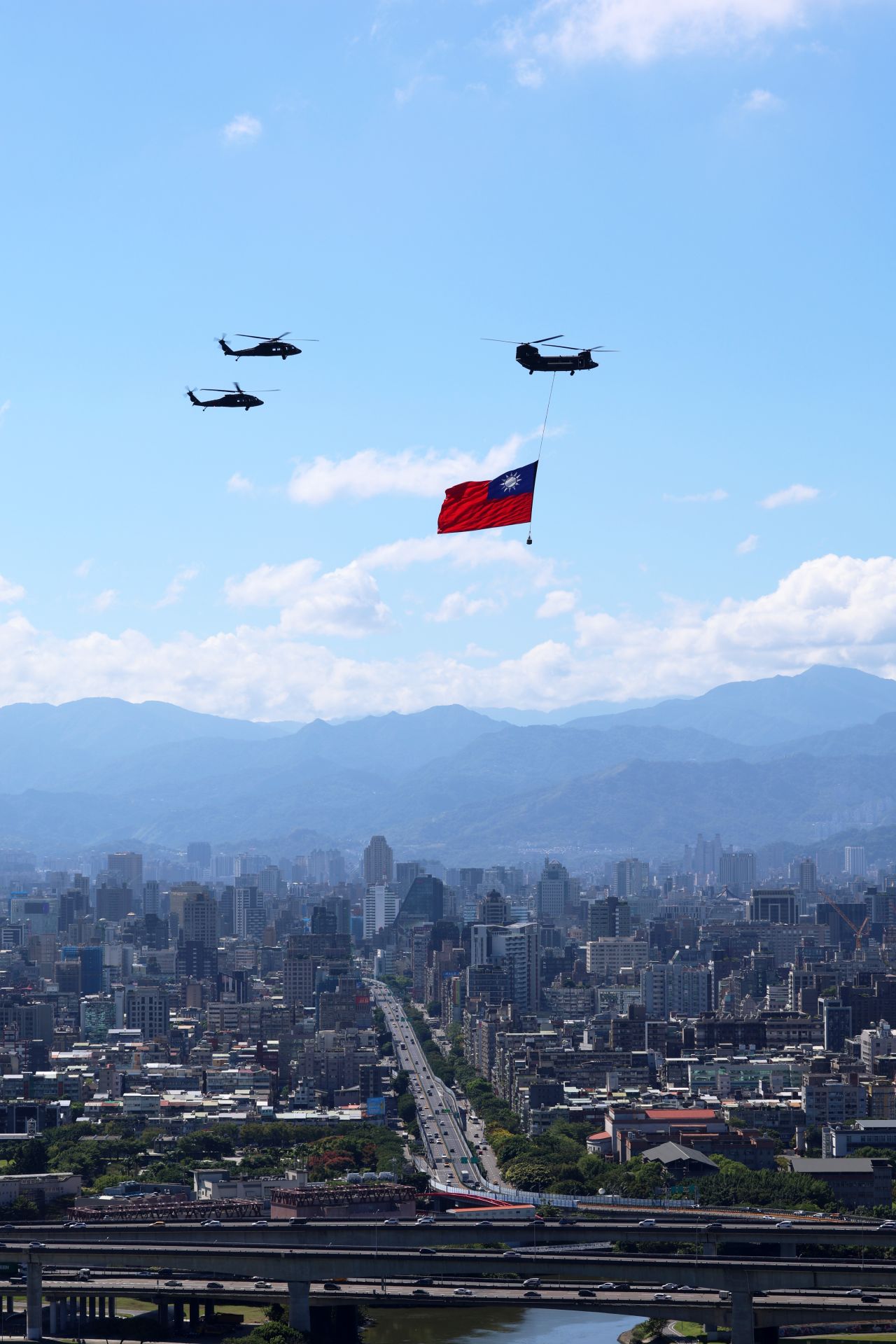 「中華民國中樞暨各界慶祝114年國慶大會」昨日盛大登場，CH-47SD運輸直升機吊掛國旗通過臺北市上空。（記者陳彥陵攝）