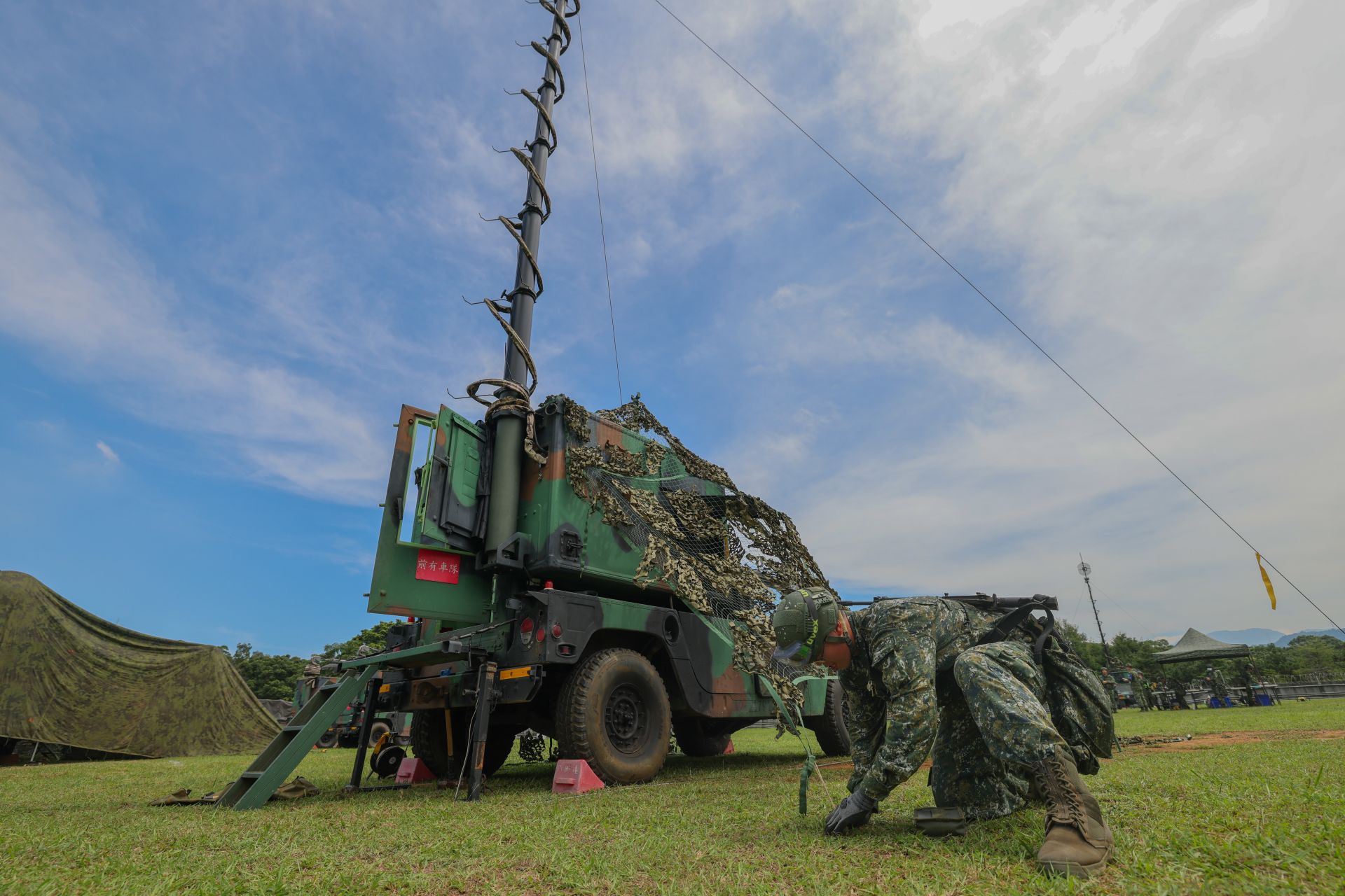  話機設定手、地樁手手持地棒奮力固定地樁，並以控繩加強繫固微波天線，進行機動數位微波系統開設。（記者王子昌攝）