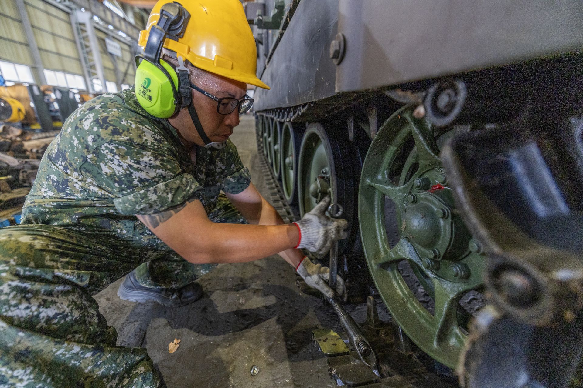  官兵為甲車安裝全新履帶，使之可持續馳騁沙場。（記者林睿奕攝）