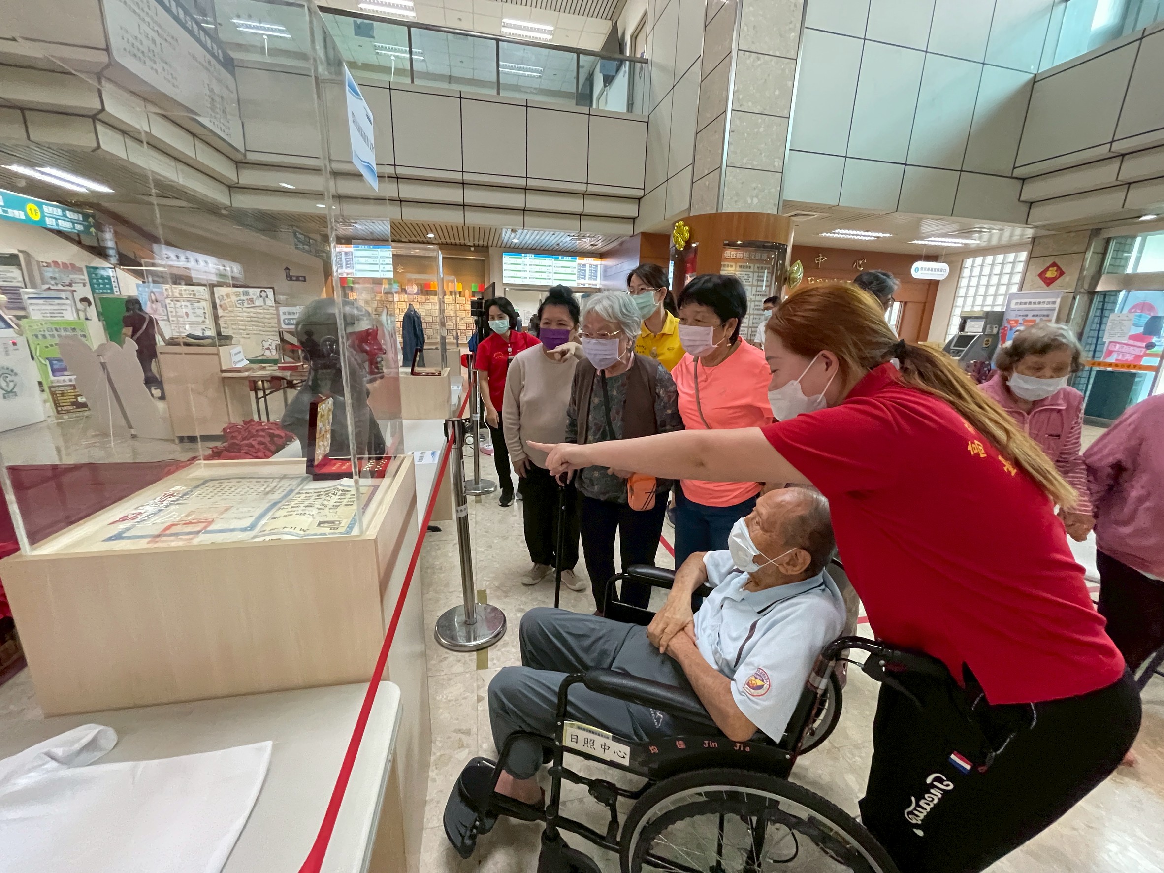 病患、家屬與住民駐足觀賞榮民文物展，細看早期軍用服裝與珍貴史料，回顧榮民奮鬥歷程。（高榮南院提供）