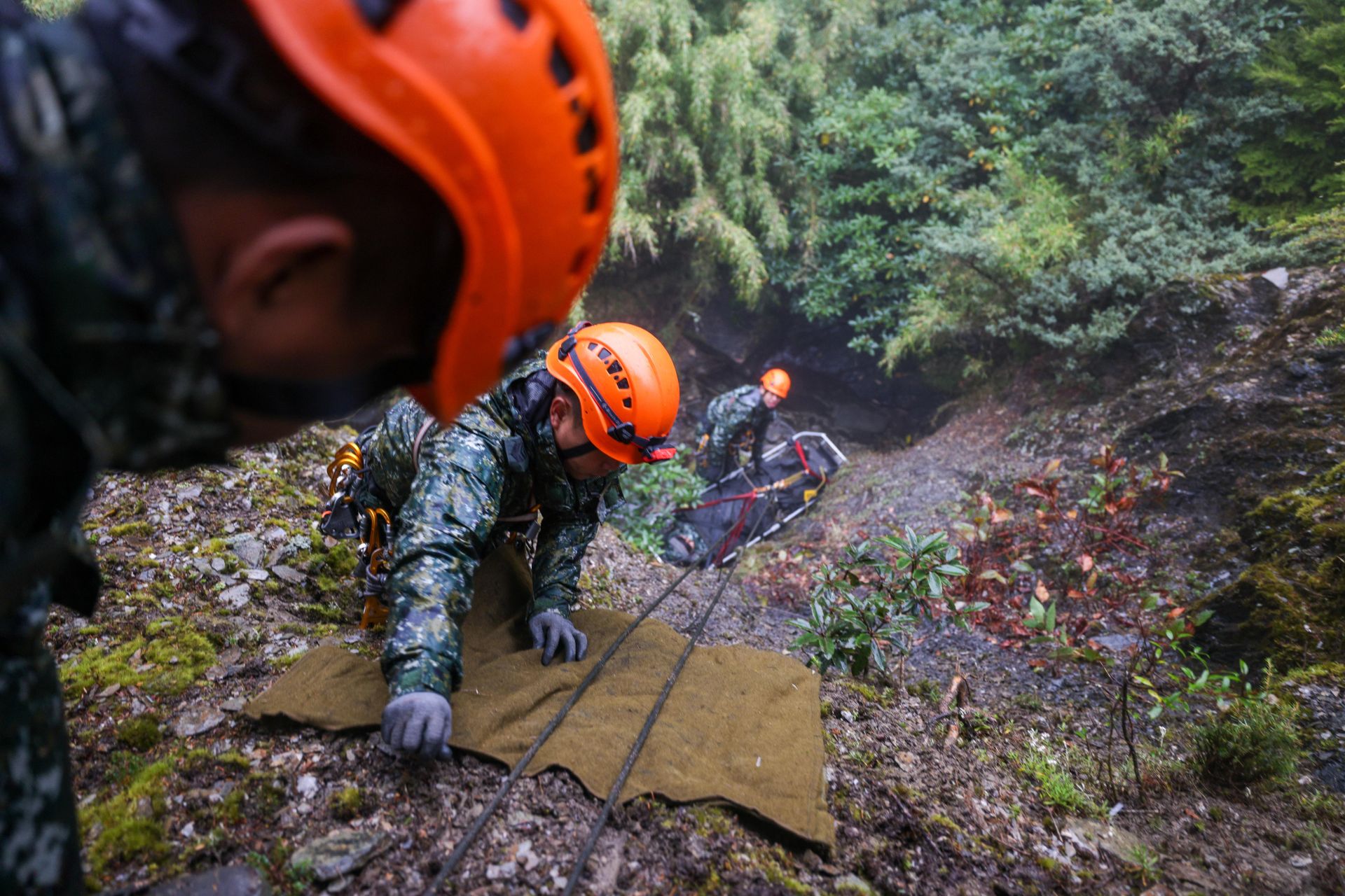 學員們分工合作、各司其職，在操作斜坡拖拉時增設軍毯，避免繩索磨損肇生危安。（記者王子昌攝）