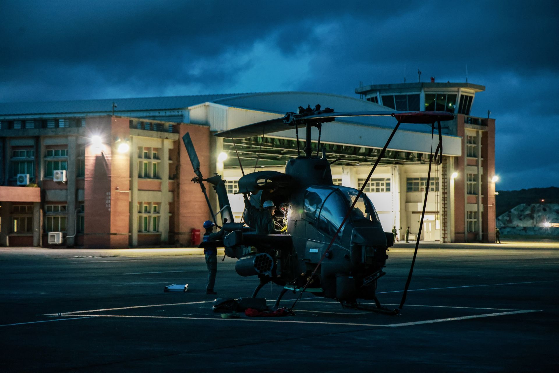 602旅飛行官與地勤人員天未破曉即機動至停機坪，頭戴頭燈、手持工具，逐架檢查飛機各項關鍵系統。（記者謝承宏攝）