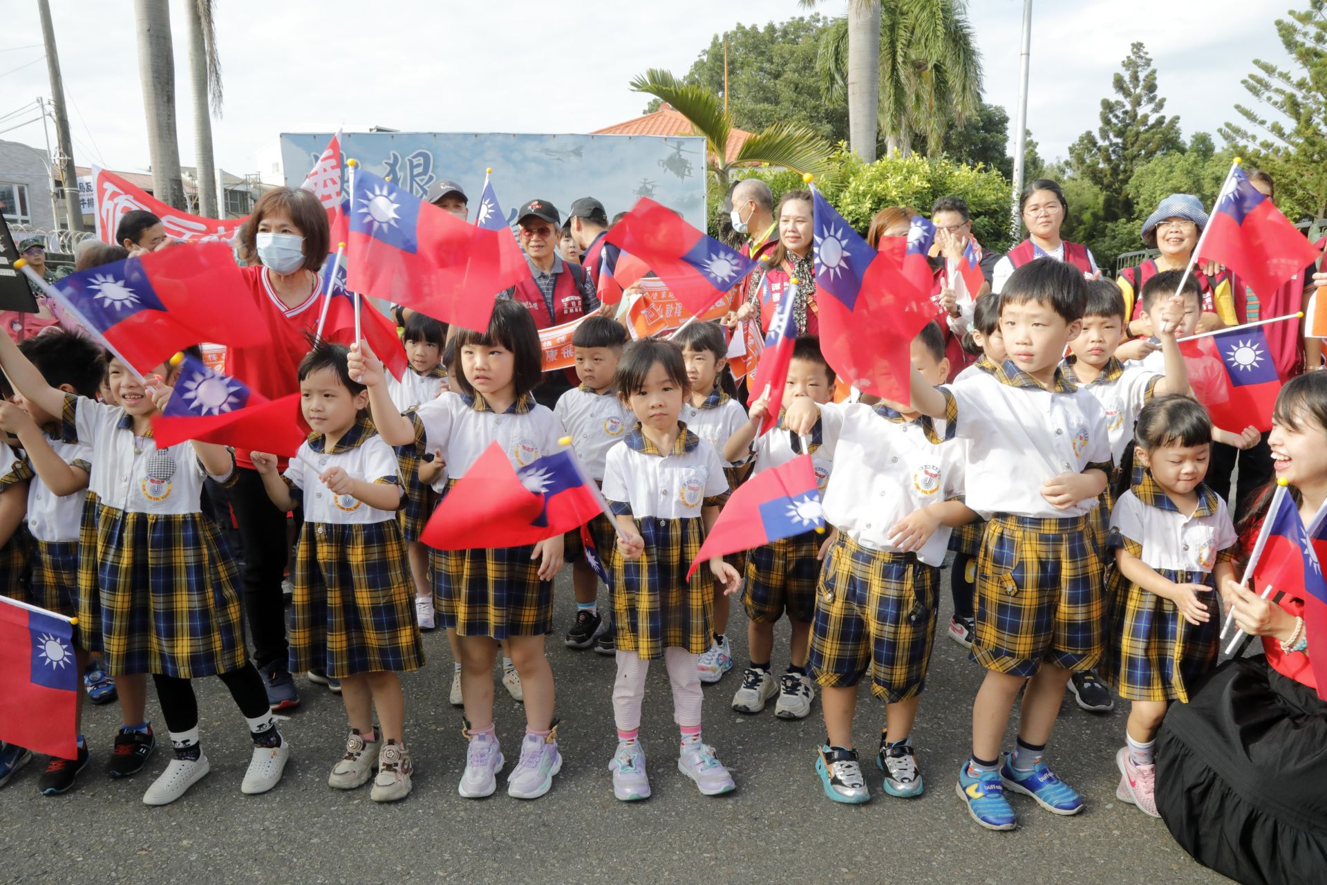 永康學童揮舞國旗歡送砲訓部官兵。（記者孫建屏攝）