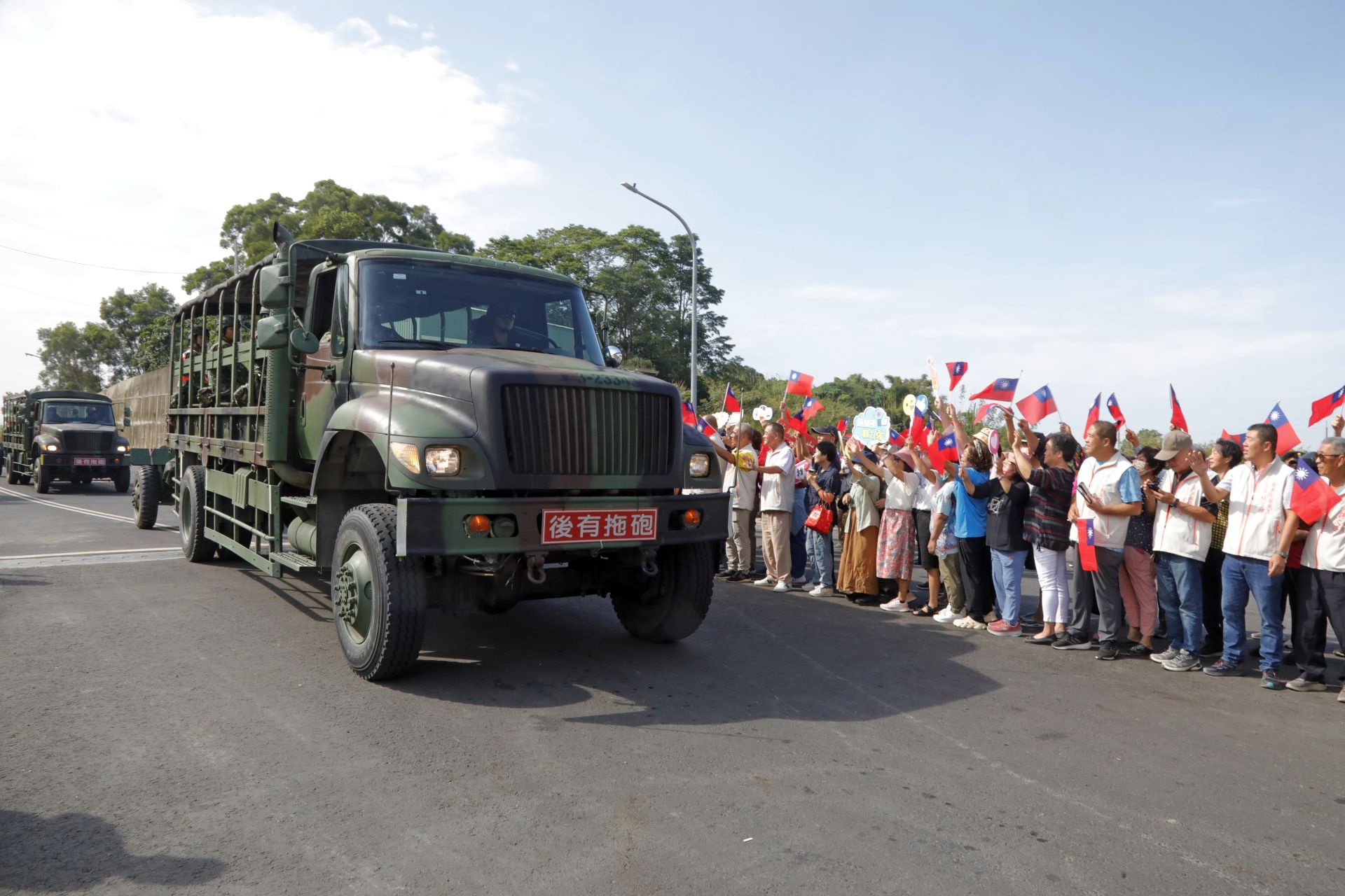 關廟地區鄉親揮舞國旗，熱情迎接砲訓部遷駐車隊。（記者孫建屏攝）