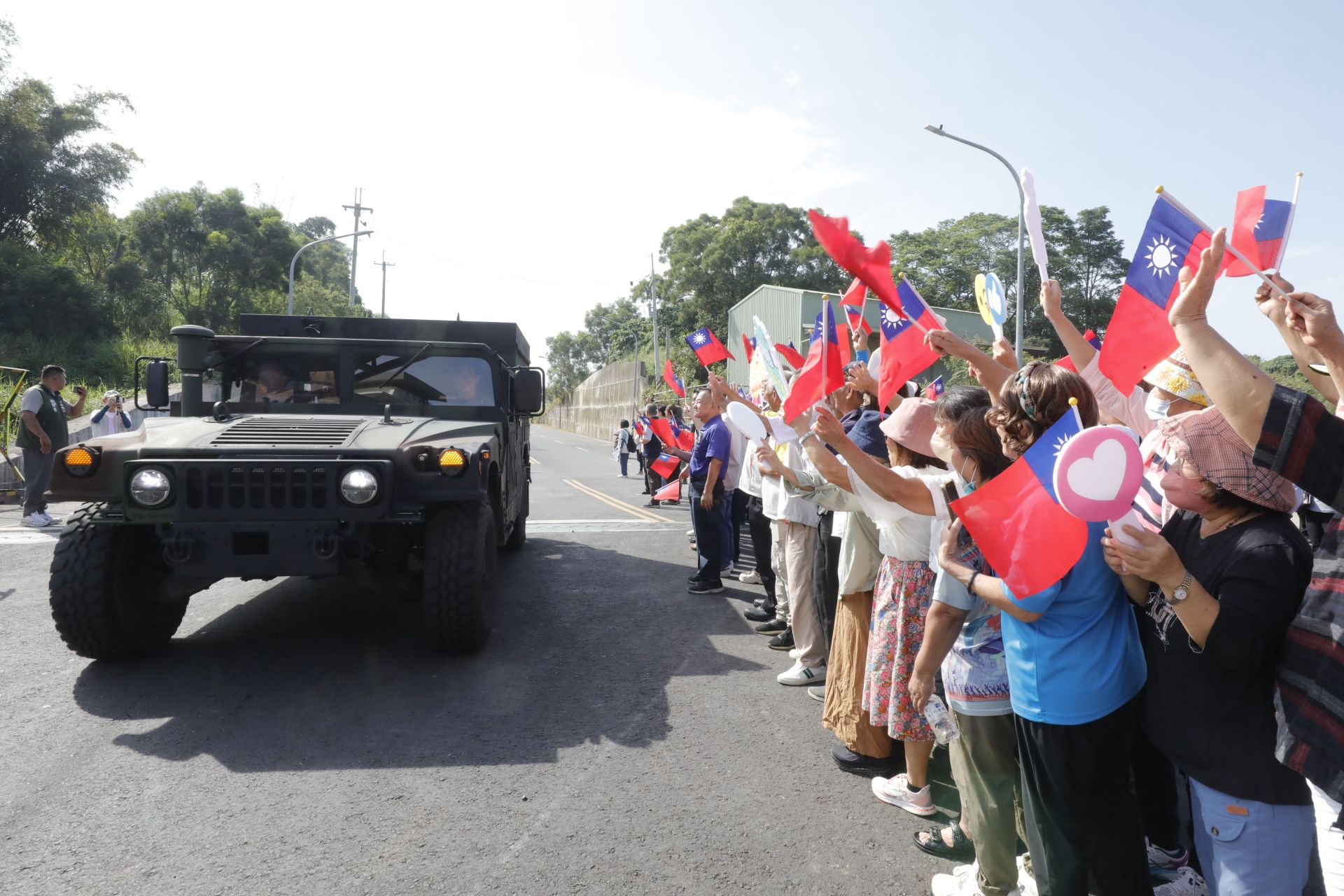 關廟地區鄉親揮舞國旗，熱情迎接砲訓部遷駐車隊。（記者孫建屏攝）