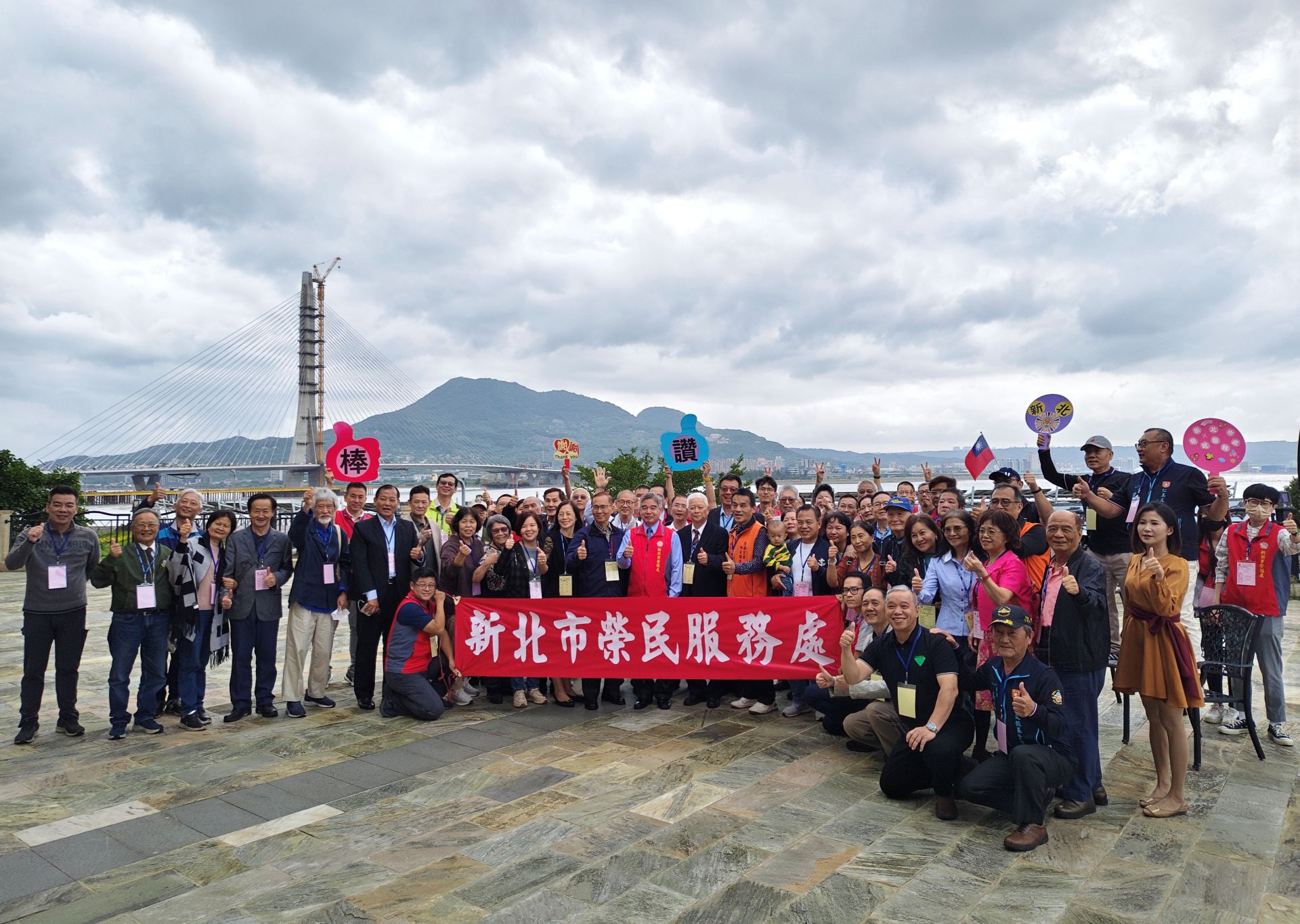 新北市榮服處處長林振生與全體來賓於淡水河前一起開心合照。（新北市榮服處提供）