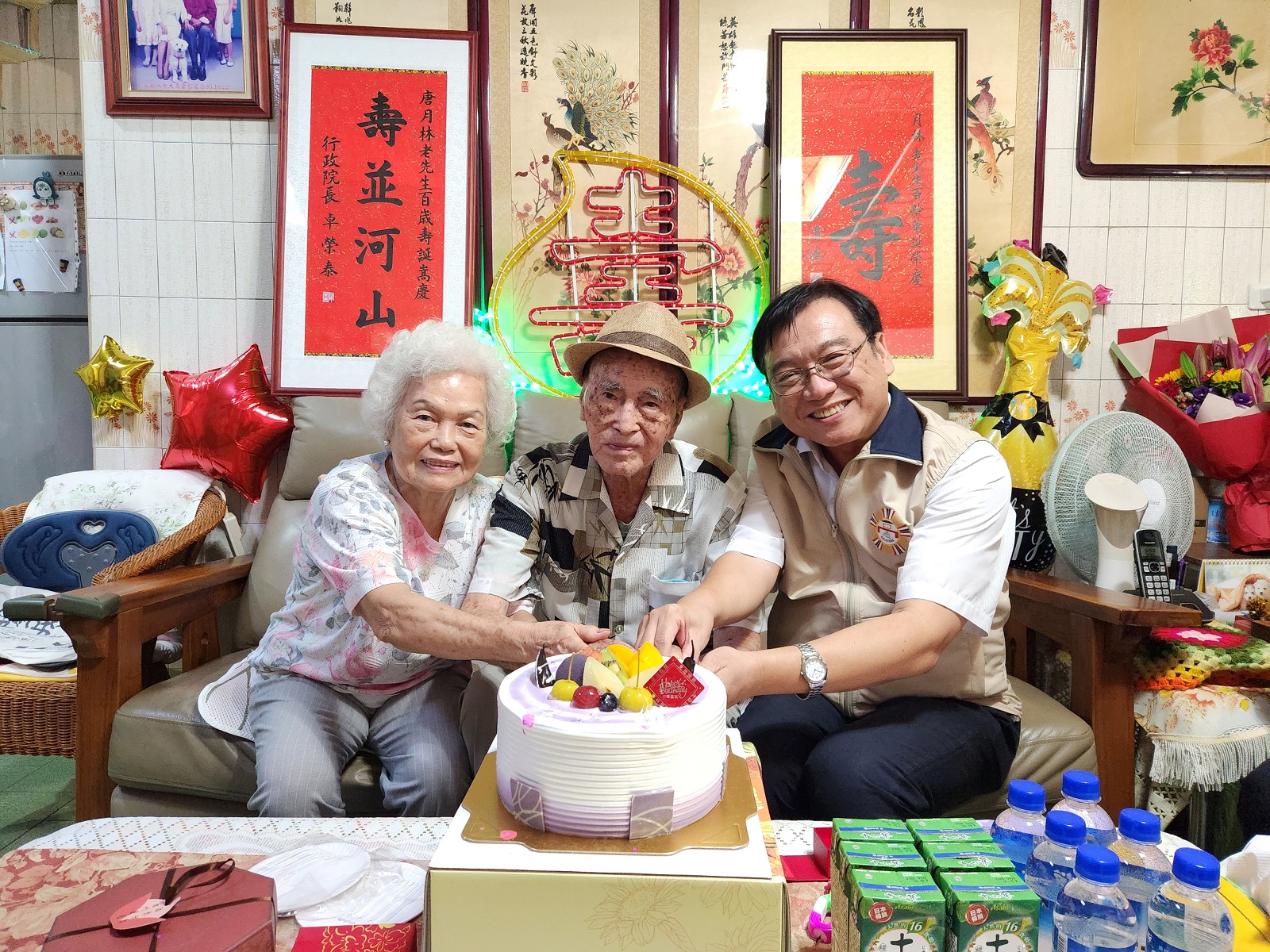 高市榮服處處長劉雅魁與壽星唐爺爺（中）及其夫人一同切壽糕慶生。（高市榮服處提供）