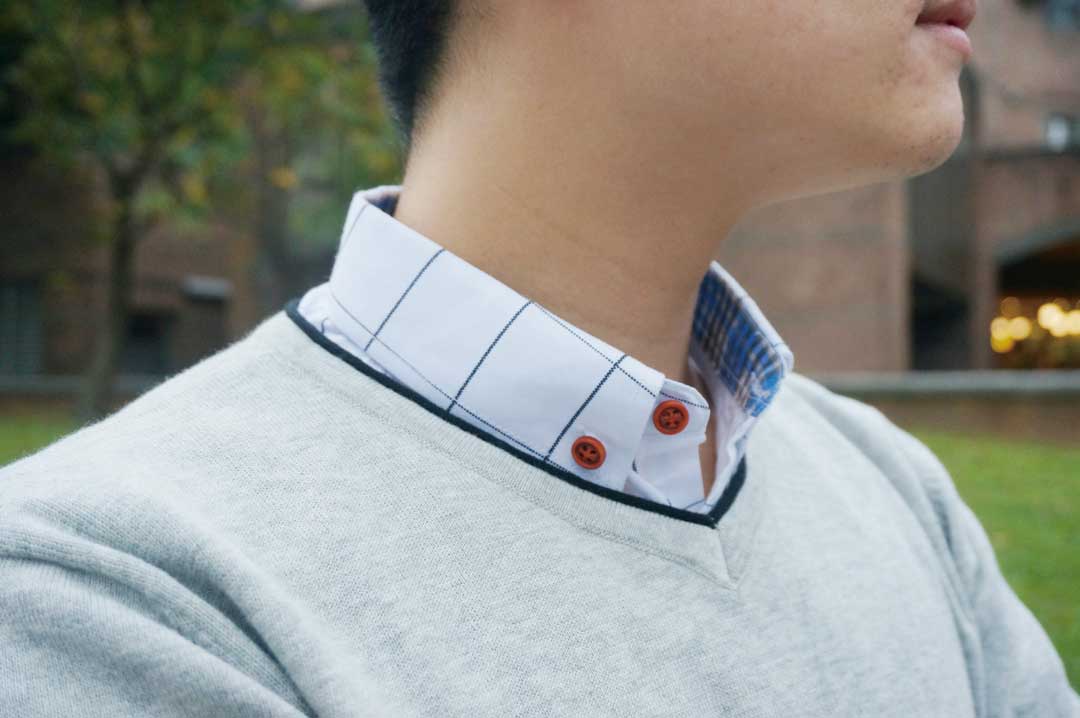 V領灰色針織衫內搭細格紋白襯衫，充滿書卷氣。