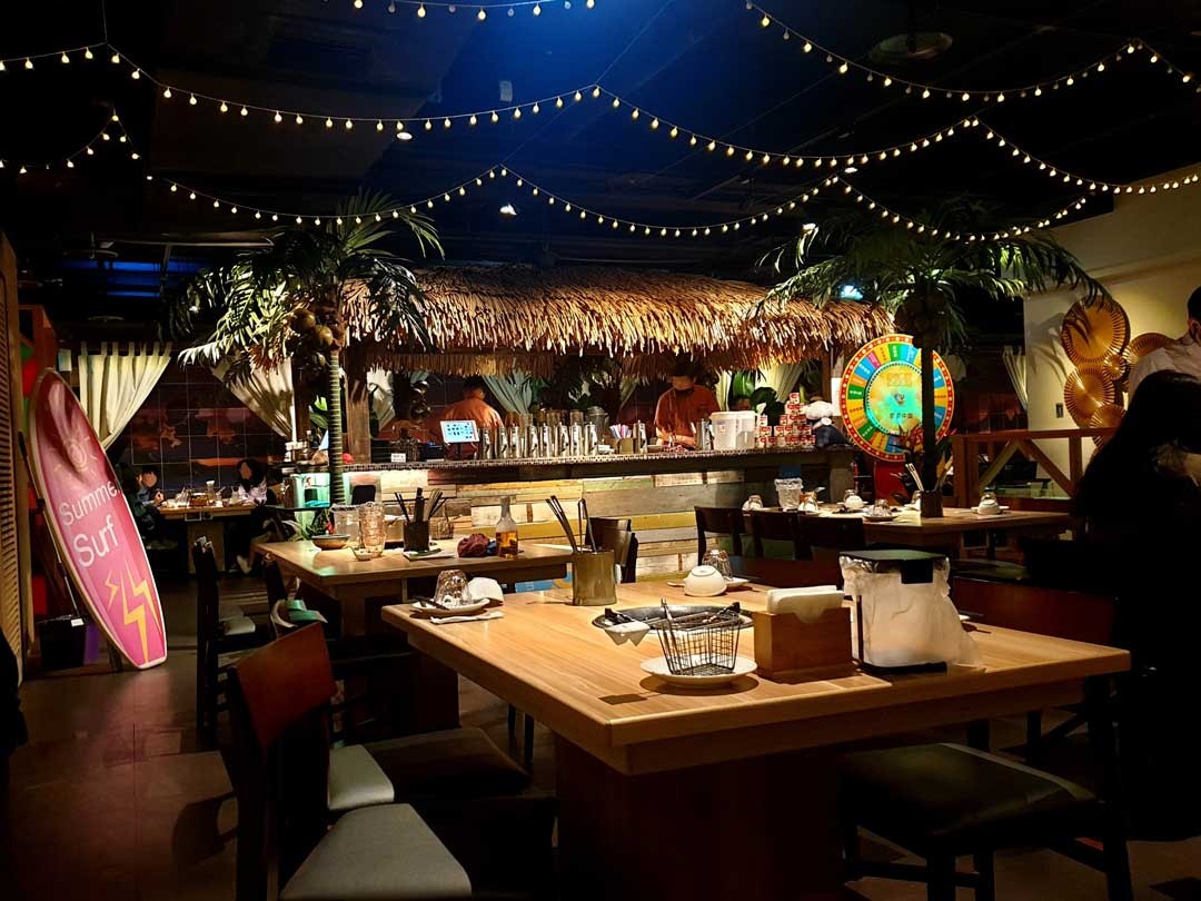 餐廳中央的茅草亭酒吧斜靠著滑板和白色布幔的Villa風卡座，成功把將泰國的意象融入環境。