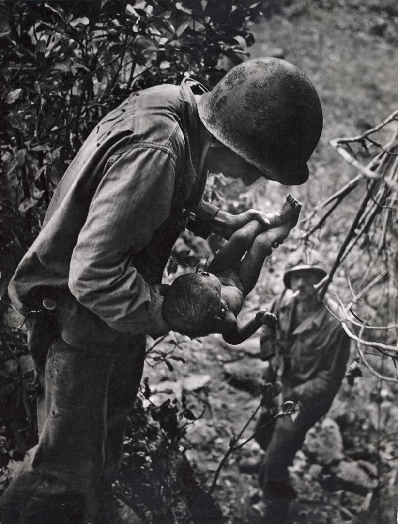 紀實攝影家尤金·史密斯，真實紀錄戰地殘酷影像，圖為〈美國海軍陸戰隊士兵在塞班島山區發現一名受傷垂死的嬰兒〉／ 1944年。